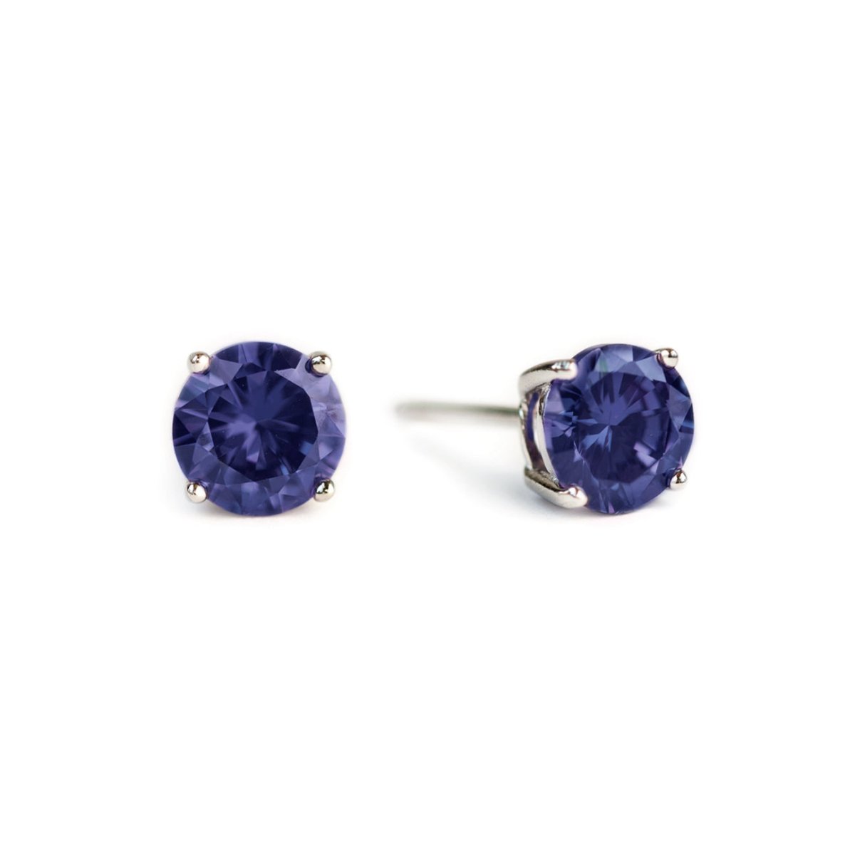 Pair of sterling silver blue sapphire studs with round violet-blue stones, on a white background