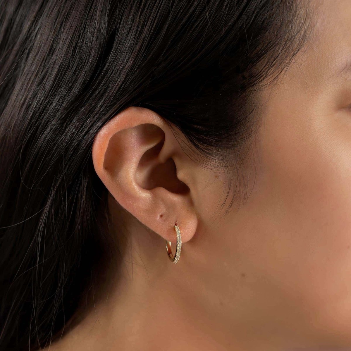 Gold vermeil pavé white zirconia small hoop shown on a model's lower earlobe