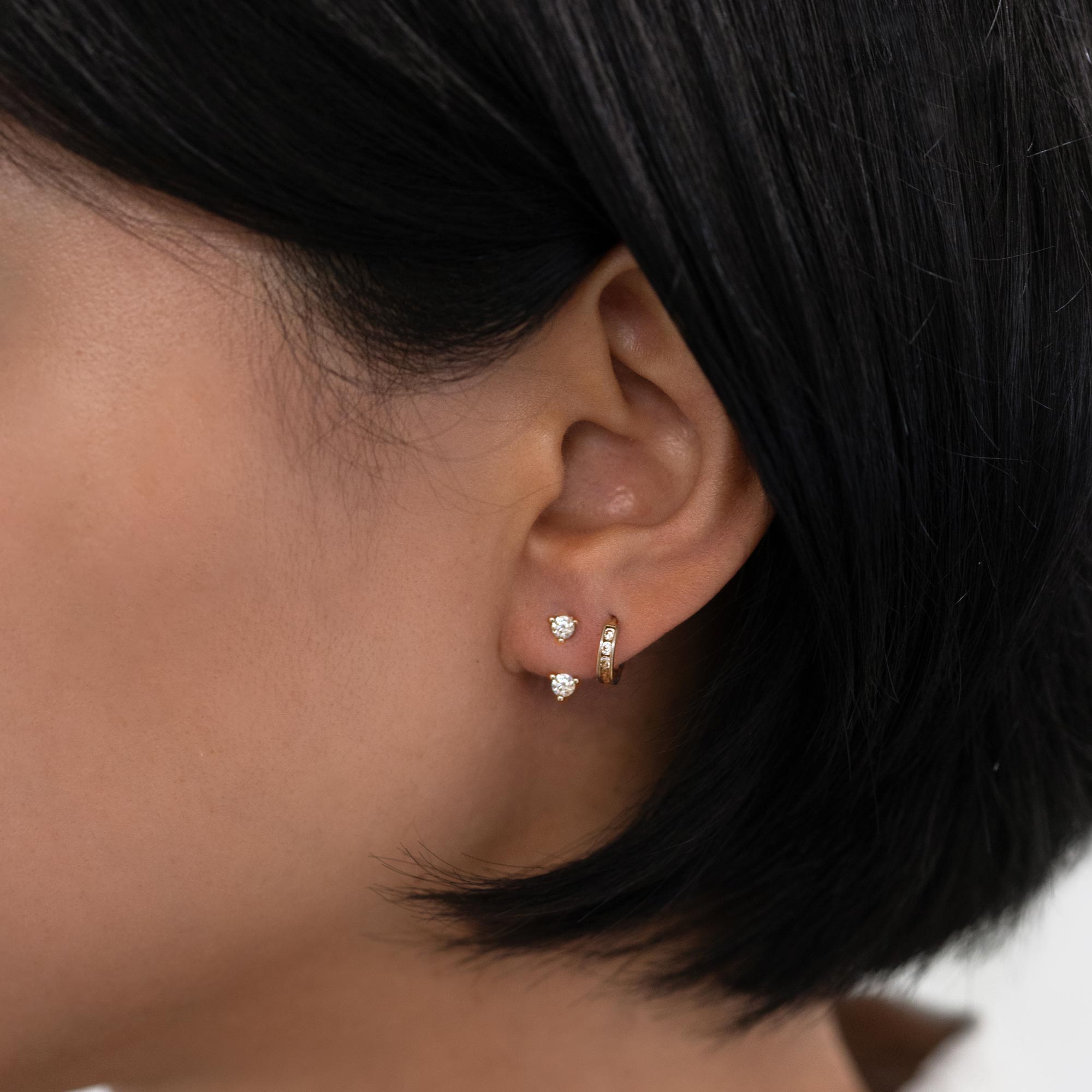 Gold vermeil white zirconia solitaire stud and pavé huggie, shown on a model's lobe