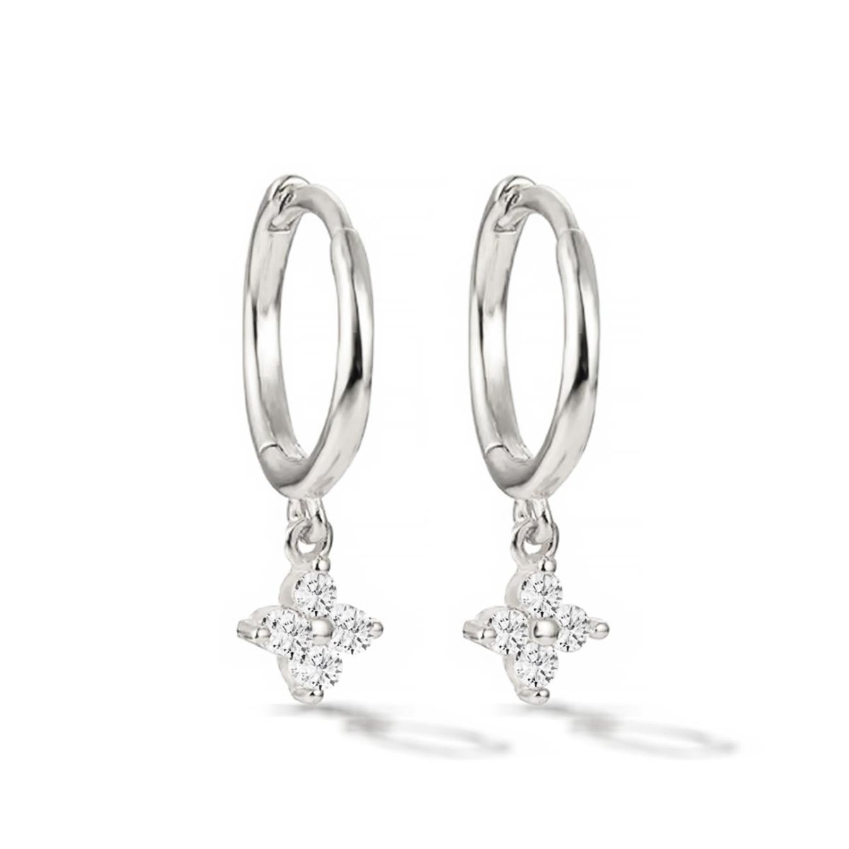 Pair of sterling silver Flor huggie hoops with a white zirconia four-stone flower, on a white background