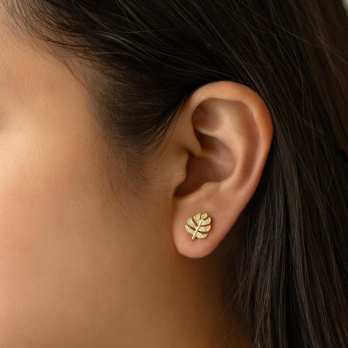 Gold vermeil monstera leaf stud earring with clear pave stones, shown on a model's lobe
