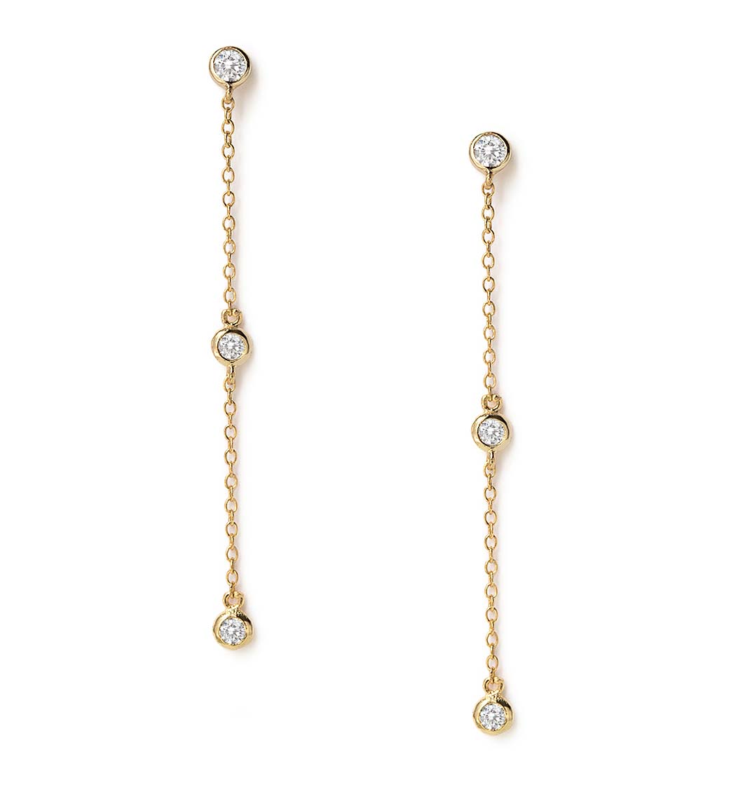 Gold vermeil drop earrings with three bezel-set round white zirconia stones on chain, on a white background