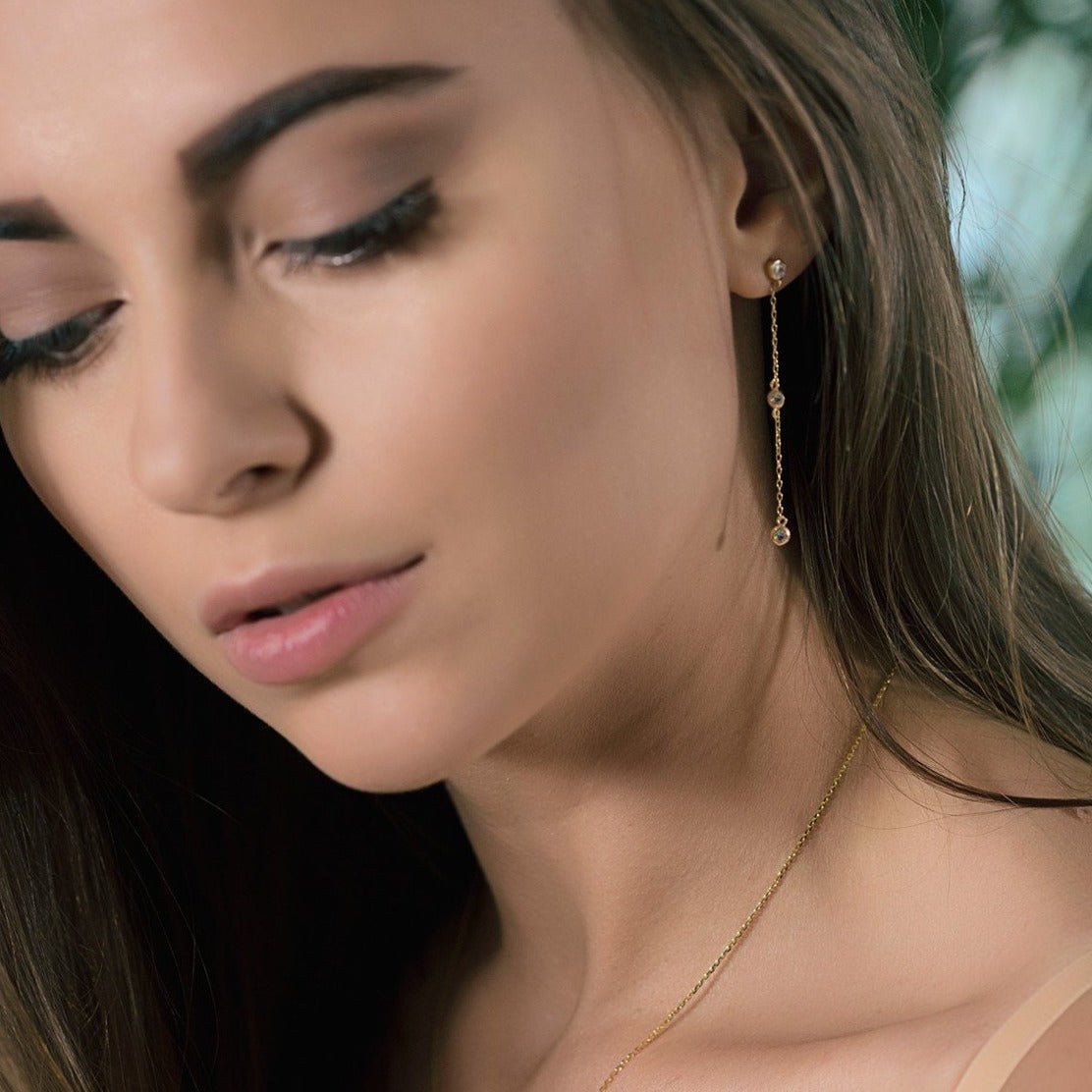 Gold vermeil white zirconia drop earring shown on a model's lobe in profile