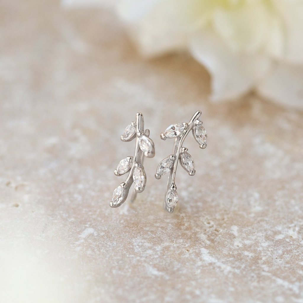 Sterling silver leaf ear climbers with marquise clear stones, on cream stone