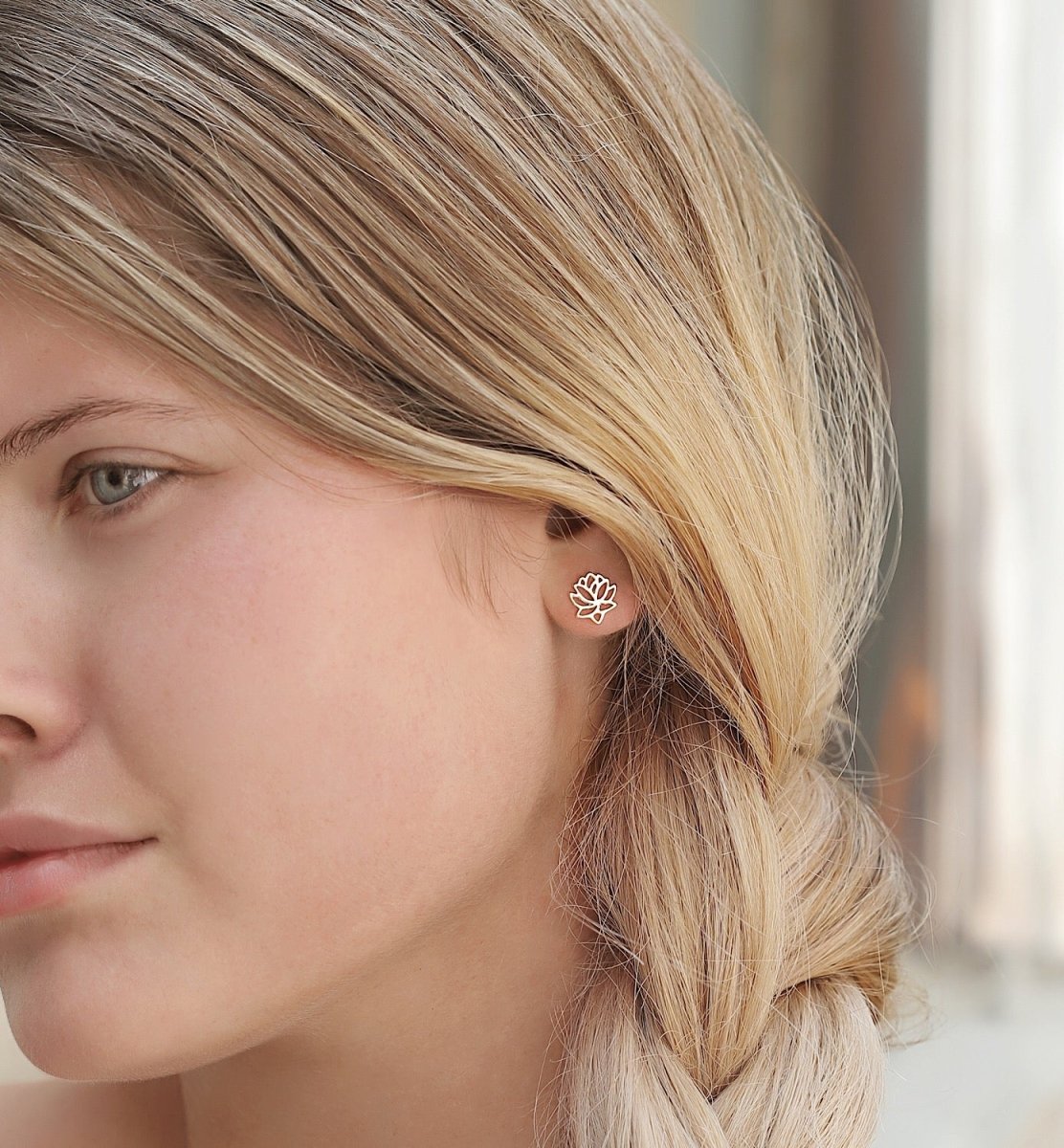 Gold vermeil lotus flower stud earring shown on a blonde model's earlobe