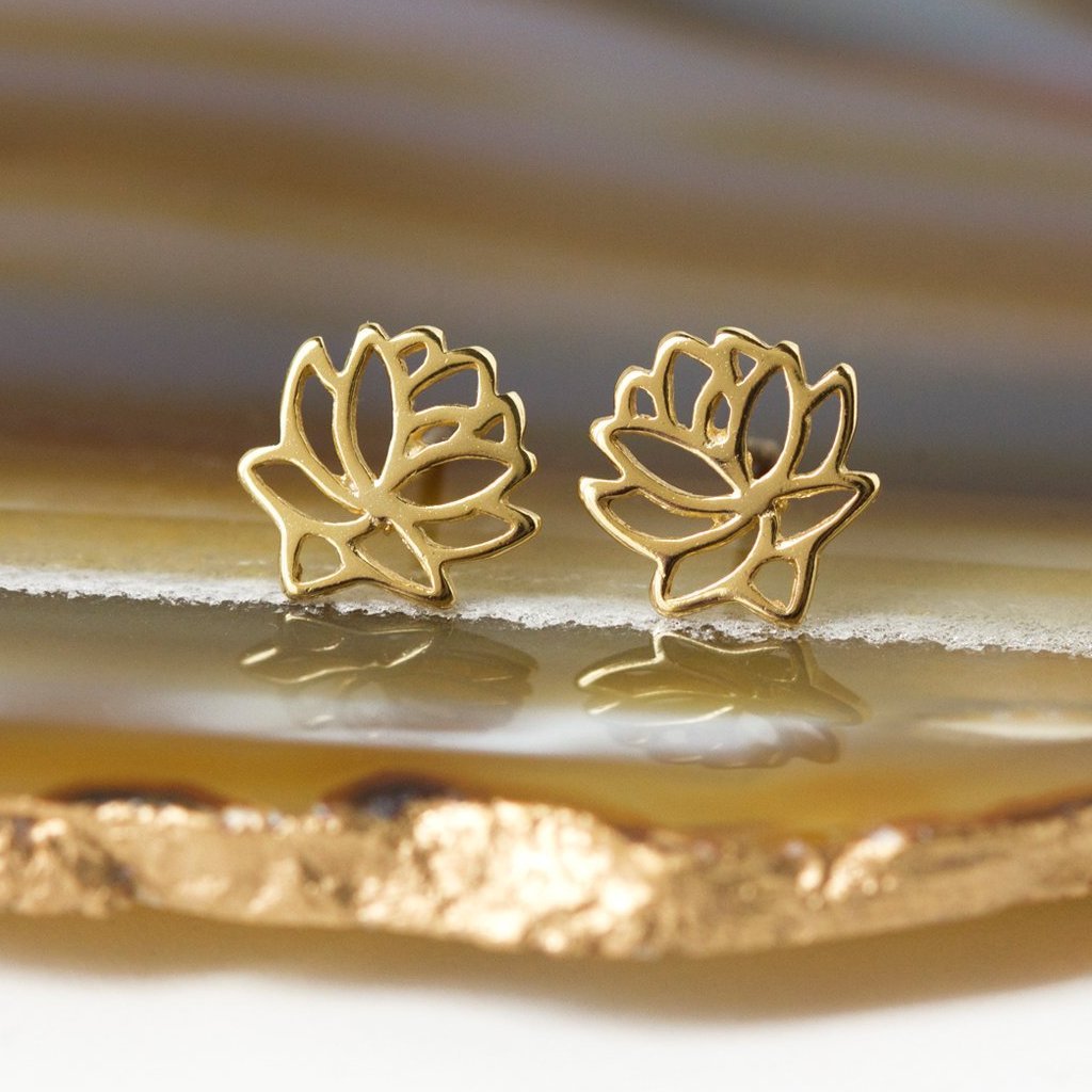 Gold vermeil lotus flower stud earrings, close-up detail on an agate slice