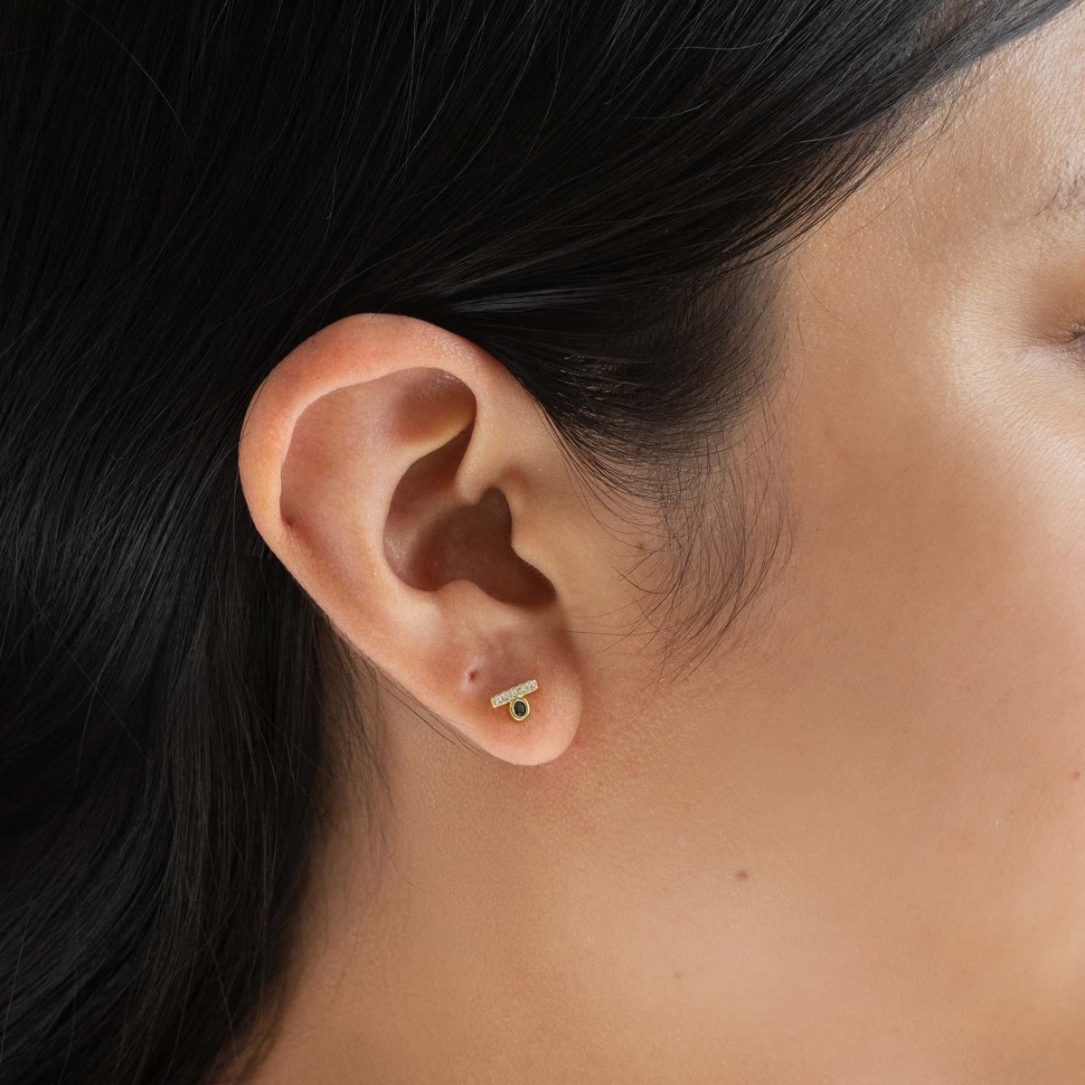 Gold vermeil pave bar and black onyx bezel studs shown on a model's lobe