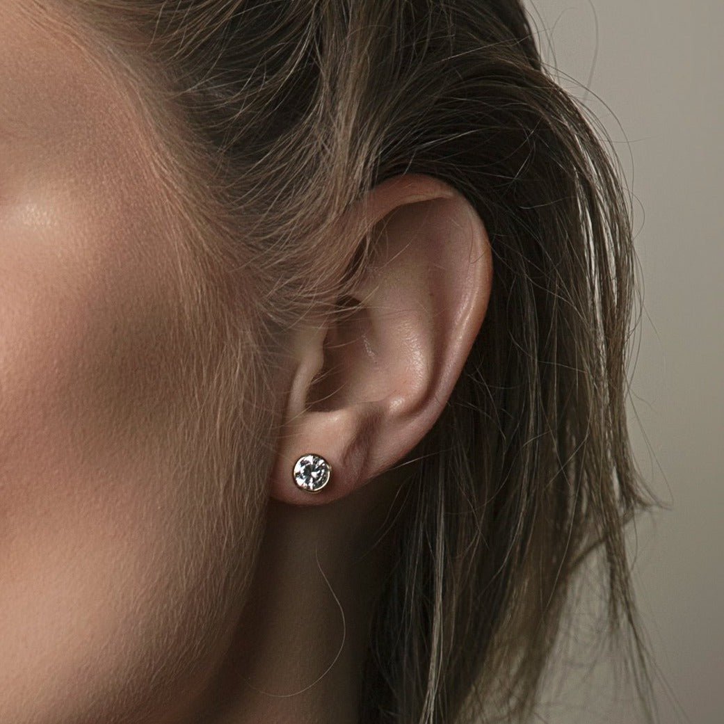 Sterling silver white zirconia stud earring shown on a model's lobe