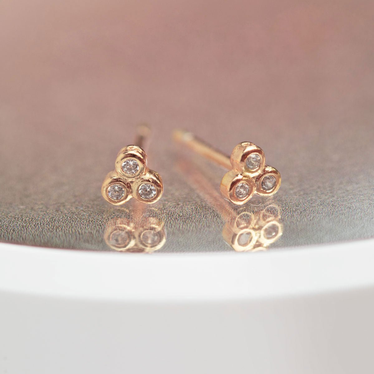 Rose gold vermeil zirconia trio studs shown on a model's ear, second piercing