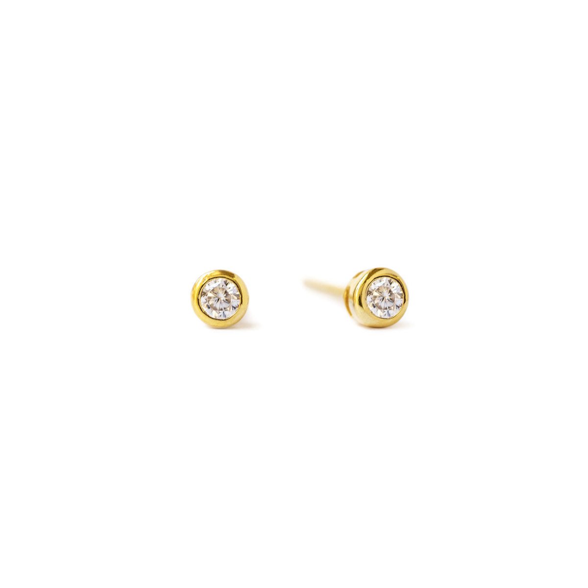 Gold vermeil bezel-set stud earrings with round white zirconia stones, on a white background