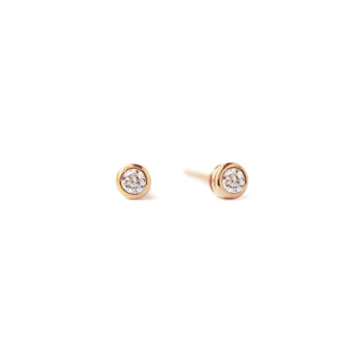 Rose gold vermeil bezel-set stud earrings with round white zirconia stones, on a white background