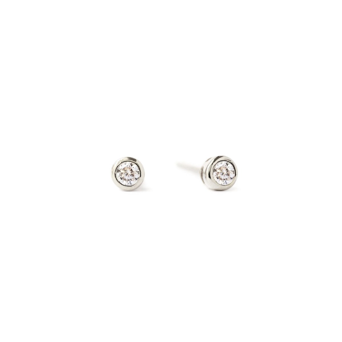 Sterling silver bezel-set stud earrings with round white zirconia stones, on a white background