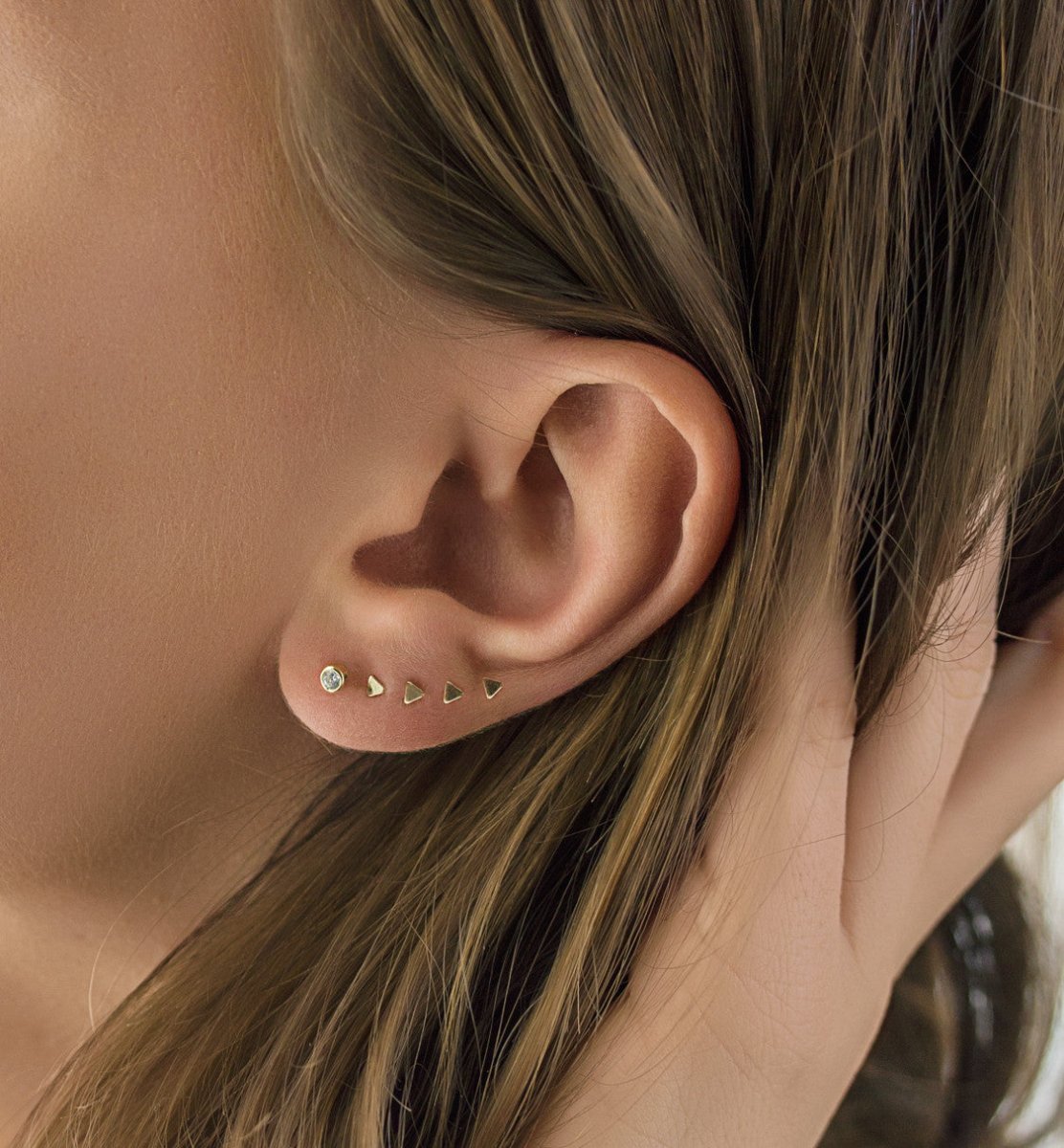 Sterling silver triangle stud styled in a lobe ear stack with a clear stone stud