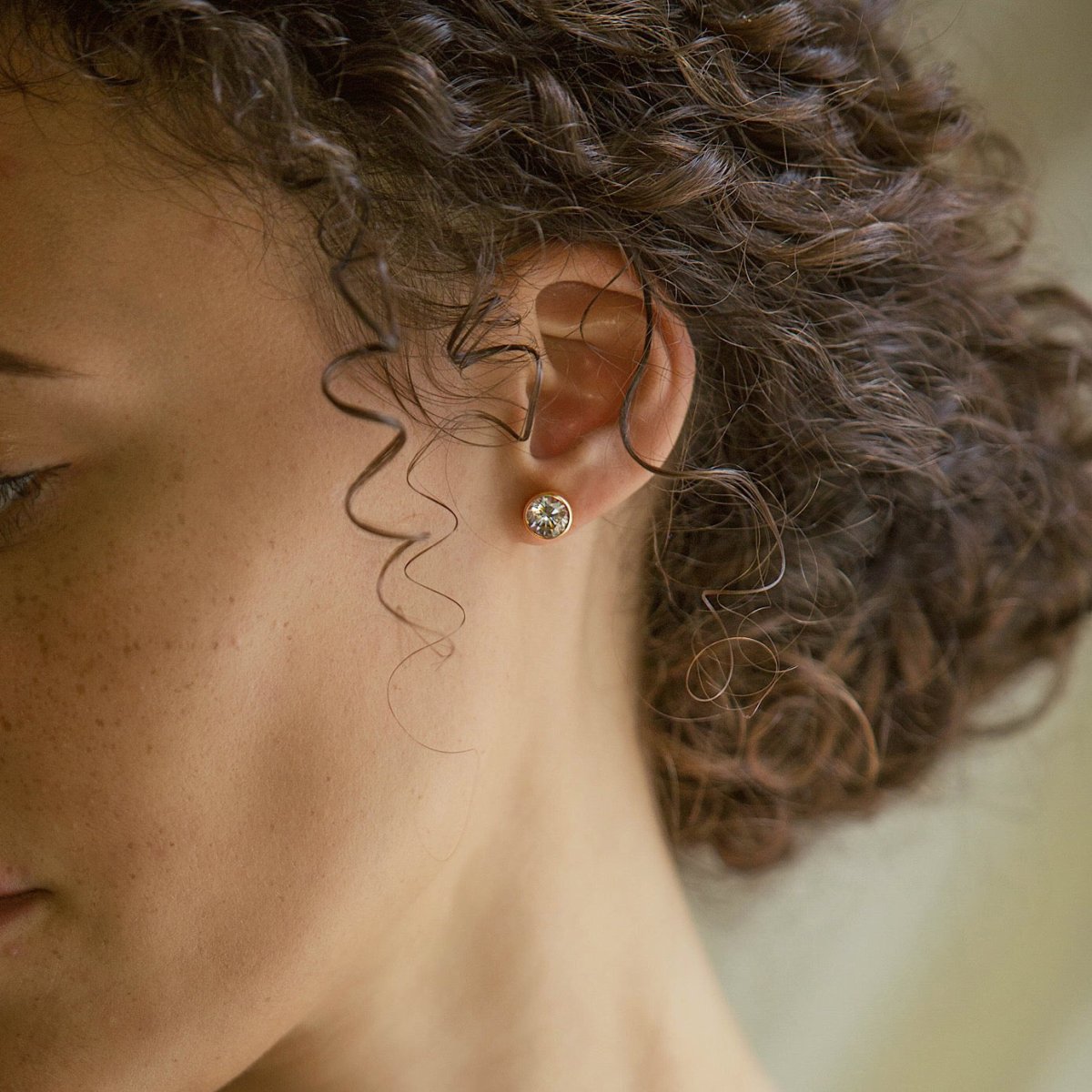 Rose gold vermeil bezel-set white zirconia stud earring shown on a model's lobe