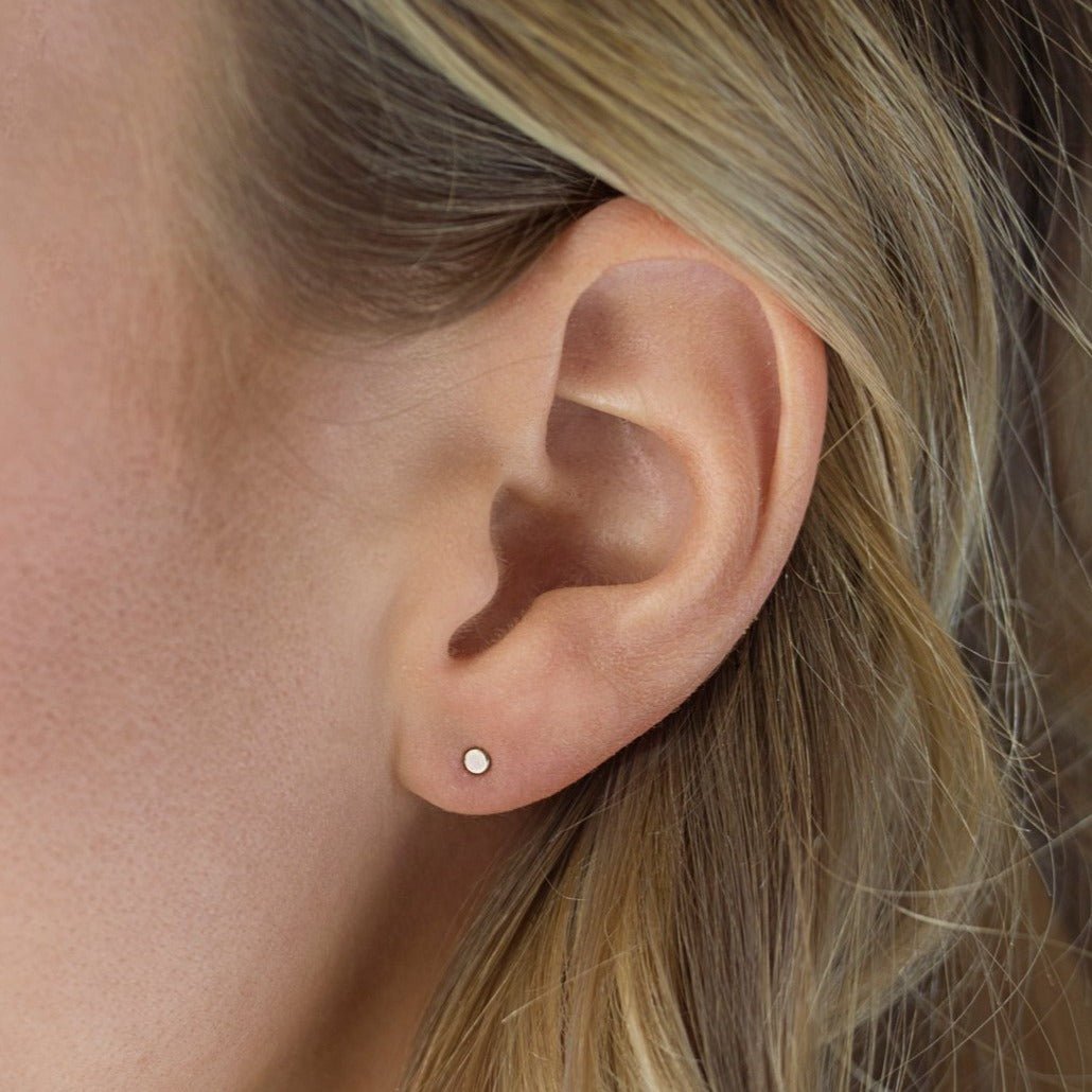 Rose gold vermeil tiny circle stud shown on a model's lobe