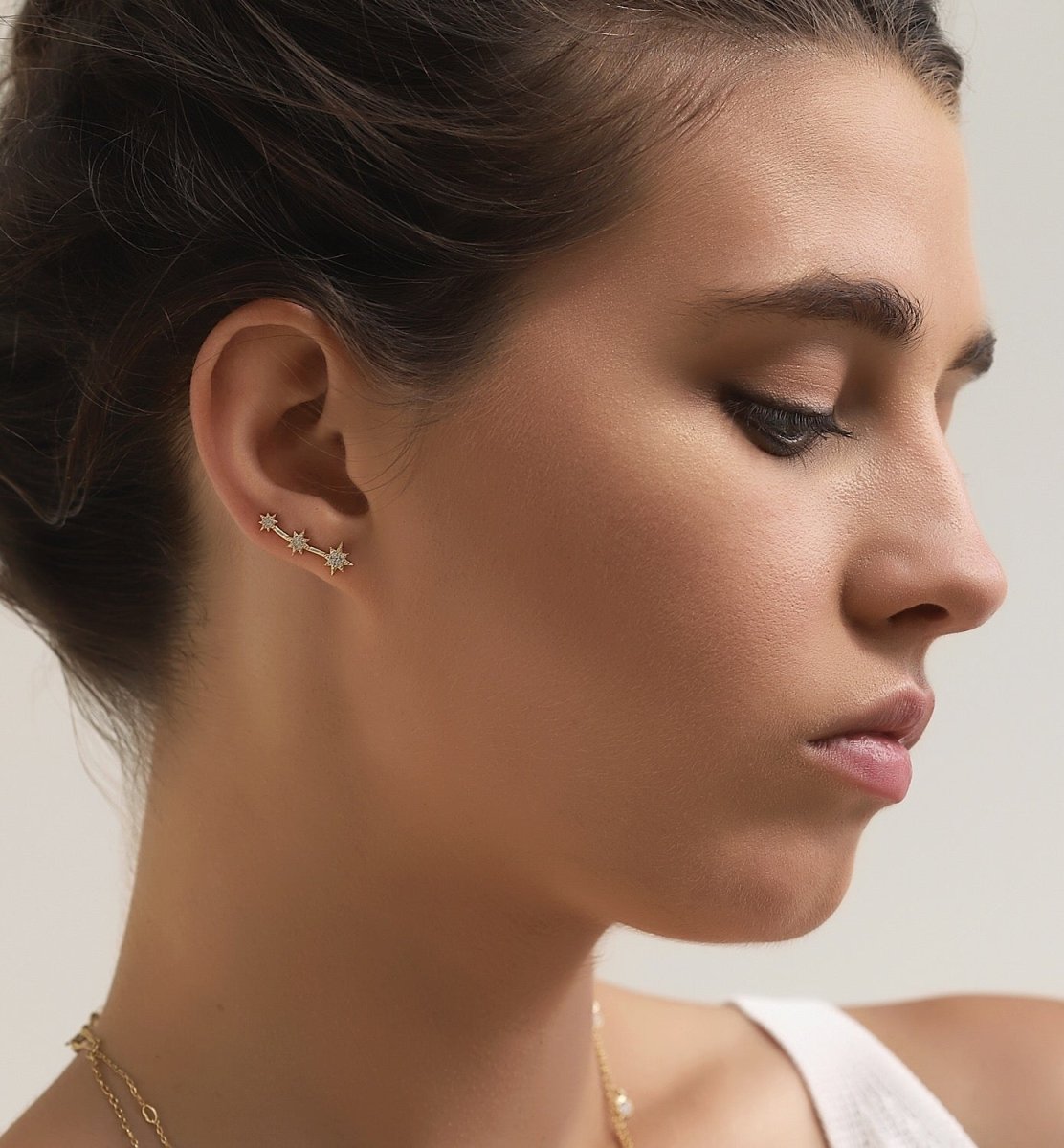 Gold vermeil three-star ear climber with white zirconia, shown on a model's lobe in profile