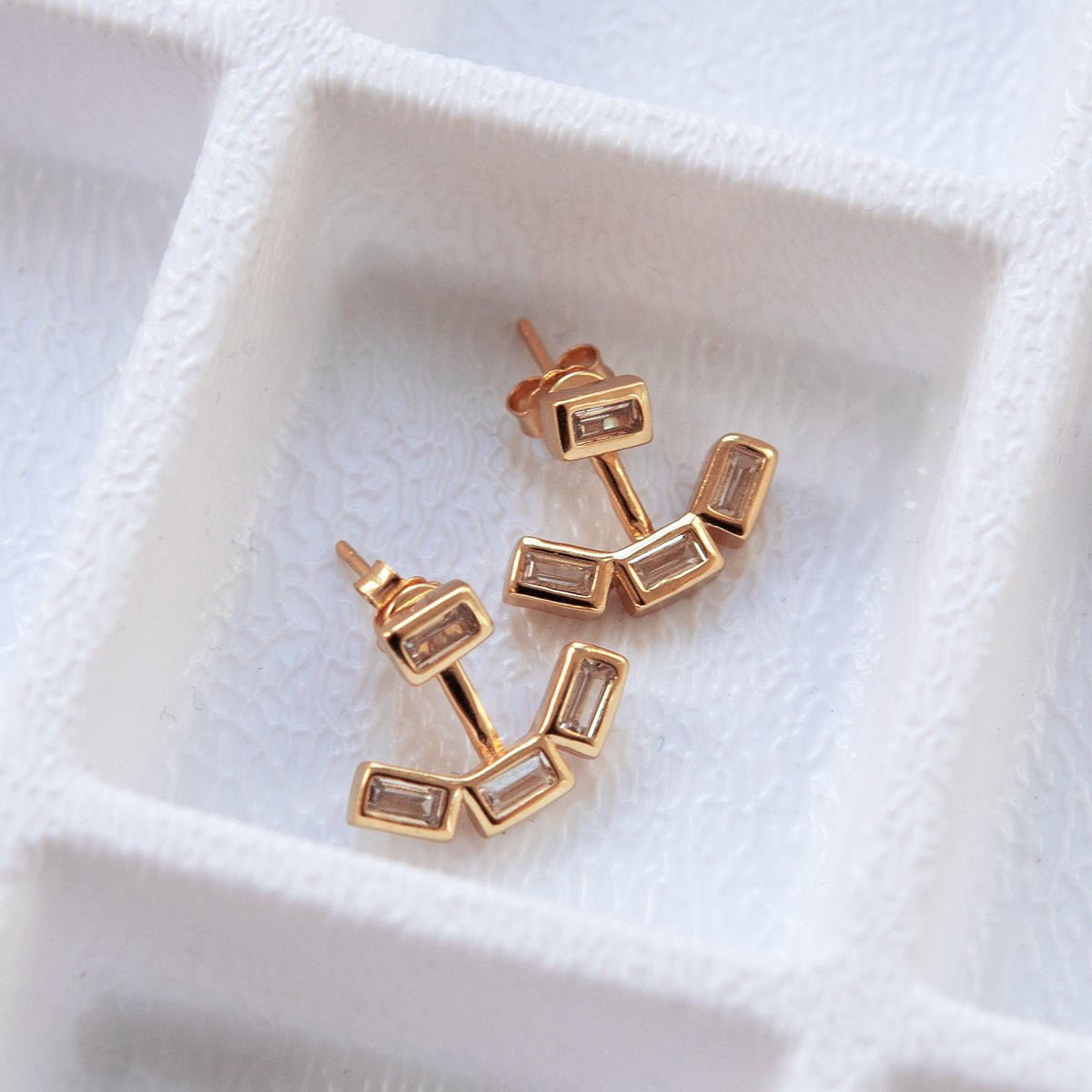 Rose gold vermeil baguette ear jacket earrings with clear stones, shown as a pair on a white background