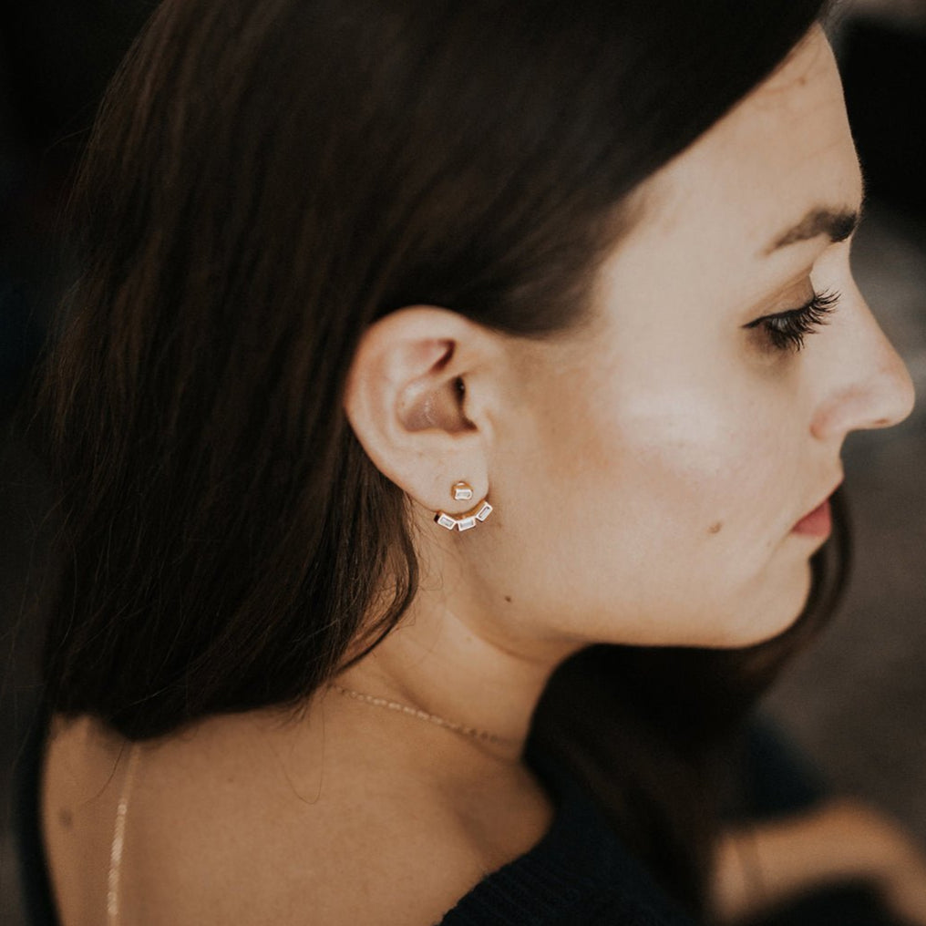 Gold vermeil baguette ear jacket with clear stones worn on a blonde model's lobe, front view
