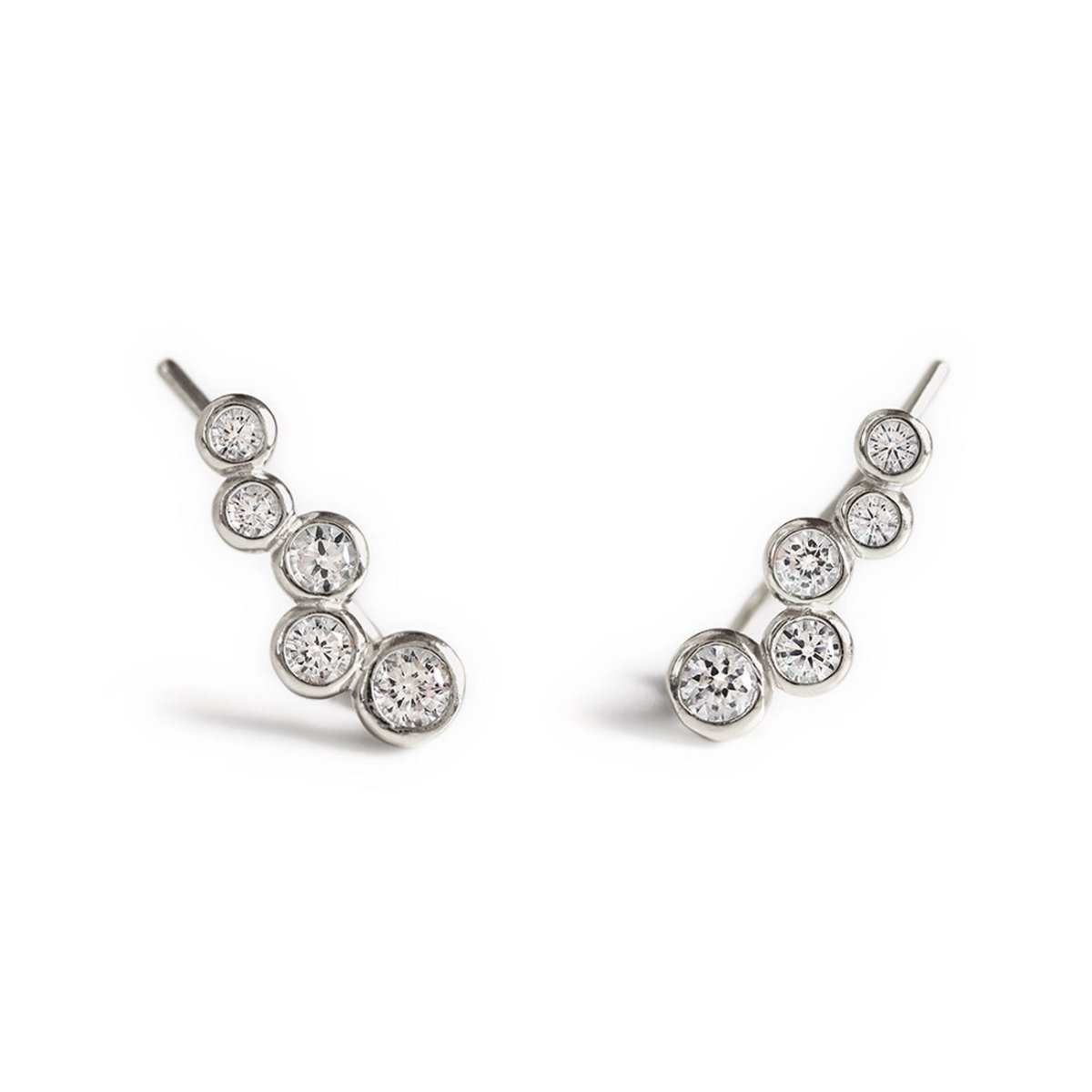 Pair of sterling silver bezel-set ear climbers with five graduated clear crystals, on a white background