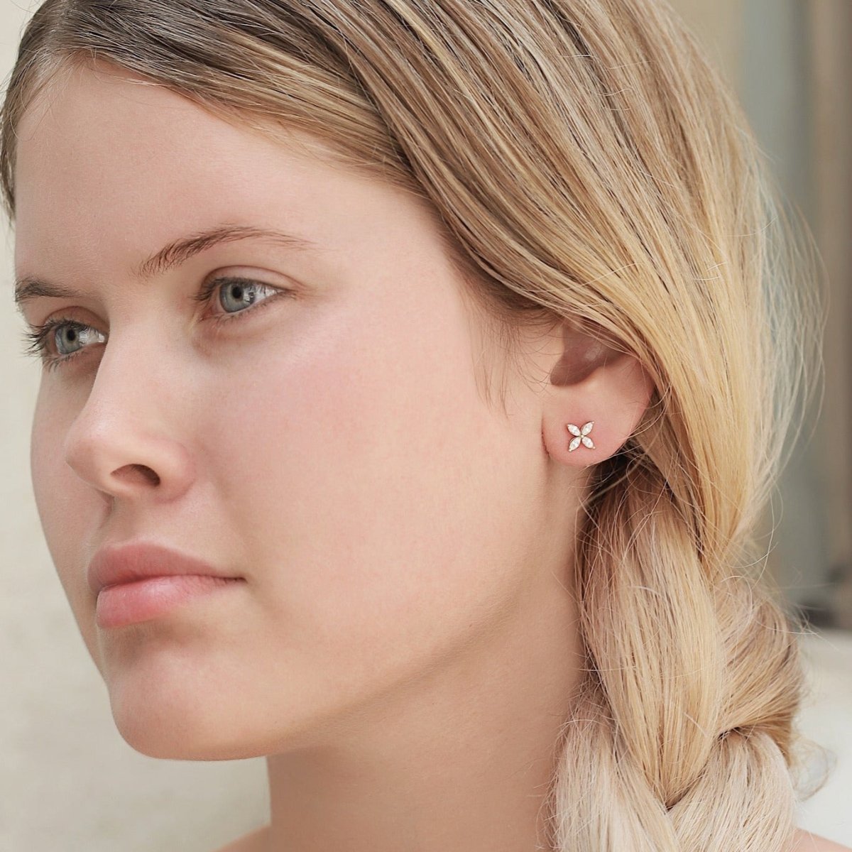 Rose gold vermeil crystal flower stud shown on a model's earlobe