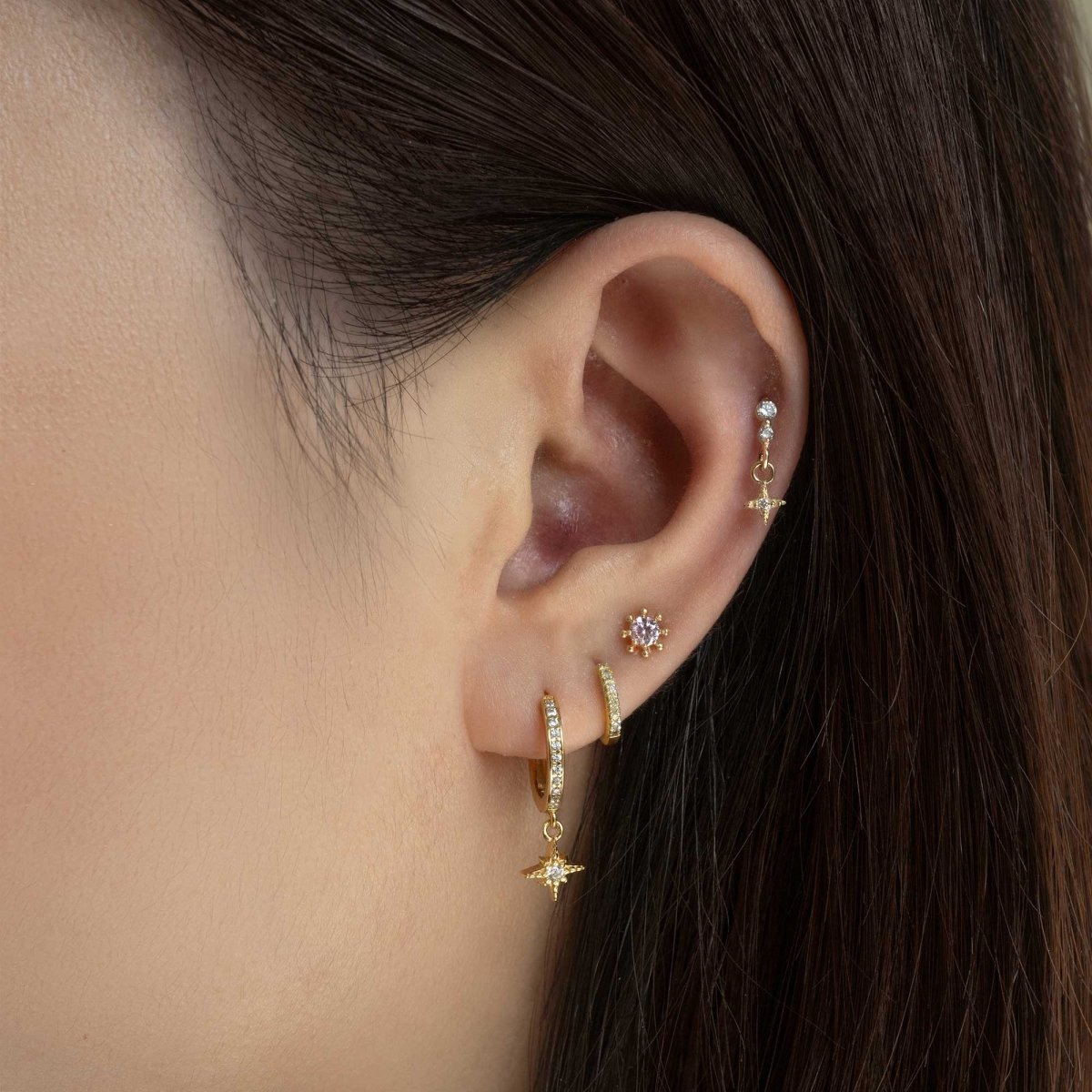14K gold falling star cartilage stud with a dangling star charm, shown on a model's helix
