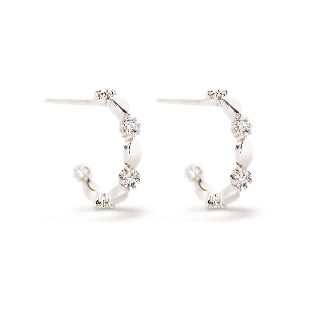 Sterling silver ornate C hoops with prong-set white zirconia stones, on a white background