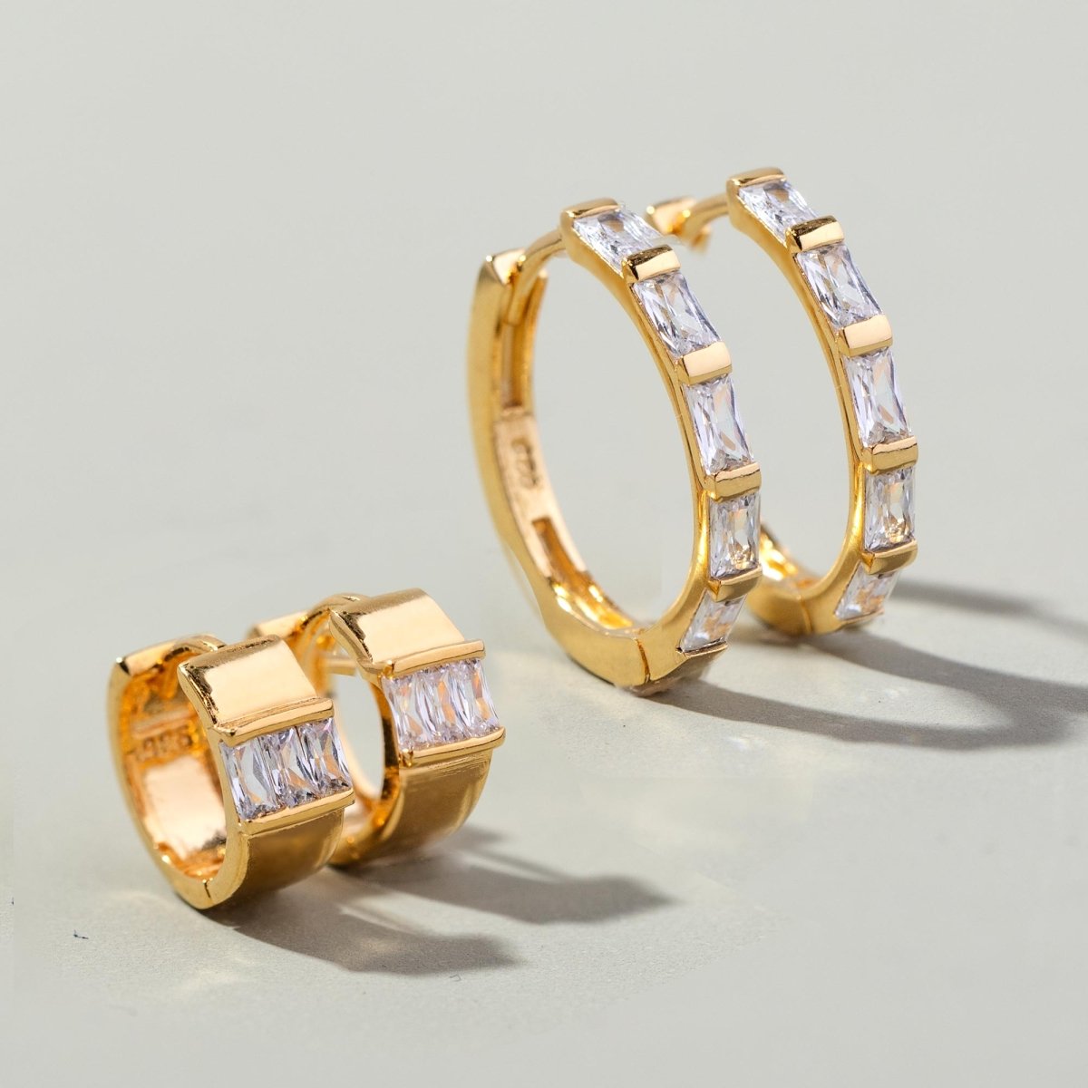 Gold vermeil baguette statement hoops with clear zirconia stones, close-up detail of the pair on grey