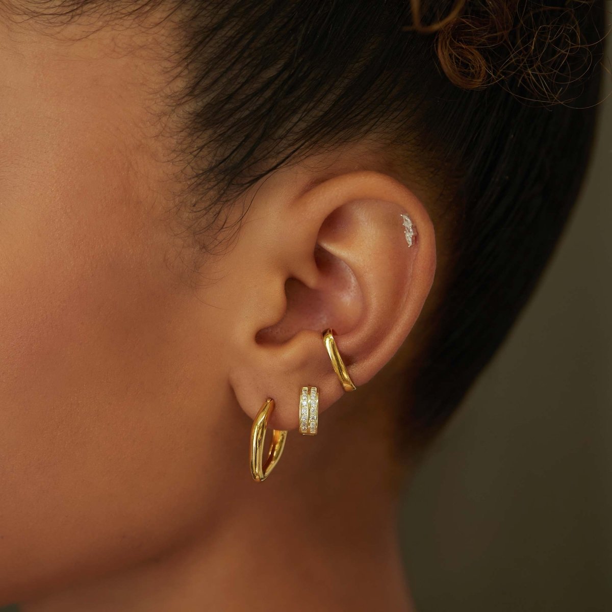 Gold vermeil bold suspender ear cuff styled with hoops in an ear stack on a model
