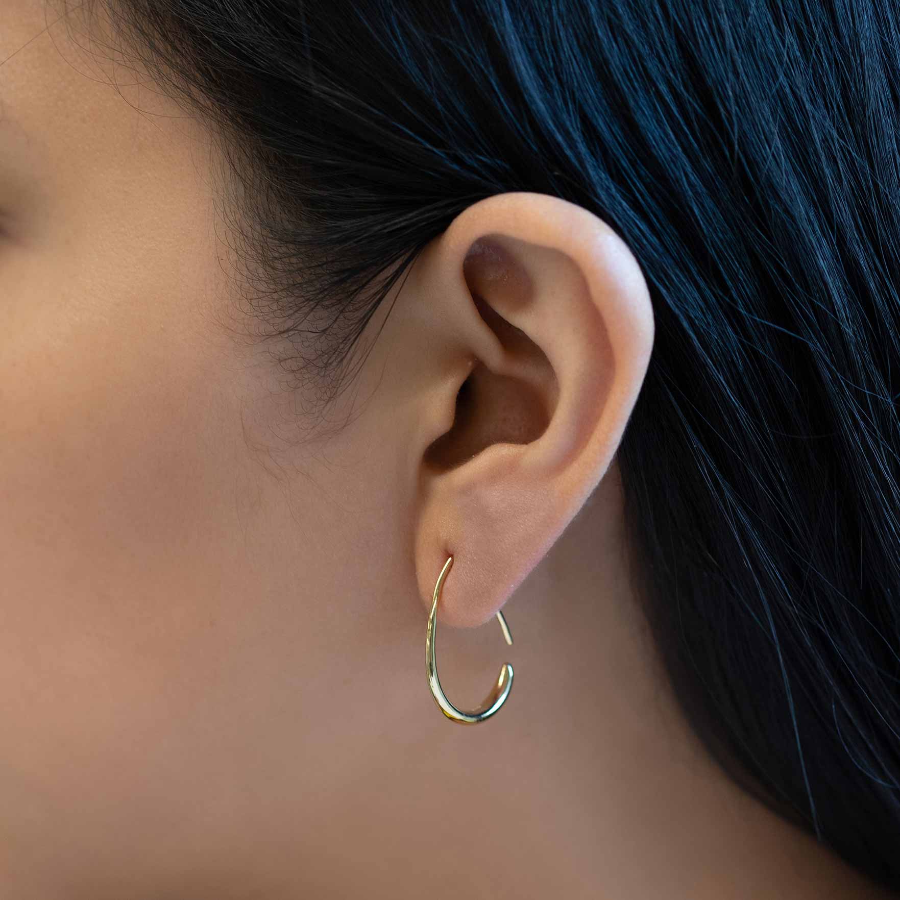 Gold vermeil teardrop open hoop earring, shown close-up on a model's lobe