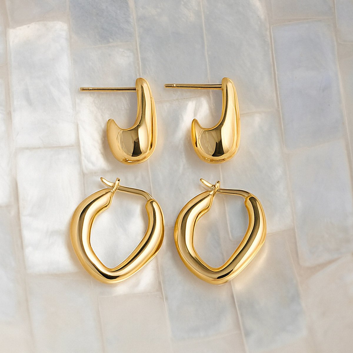 Gold vermeil sculptural drop studs and mini hoops, size comparison on white marble