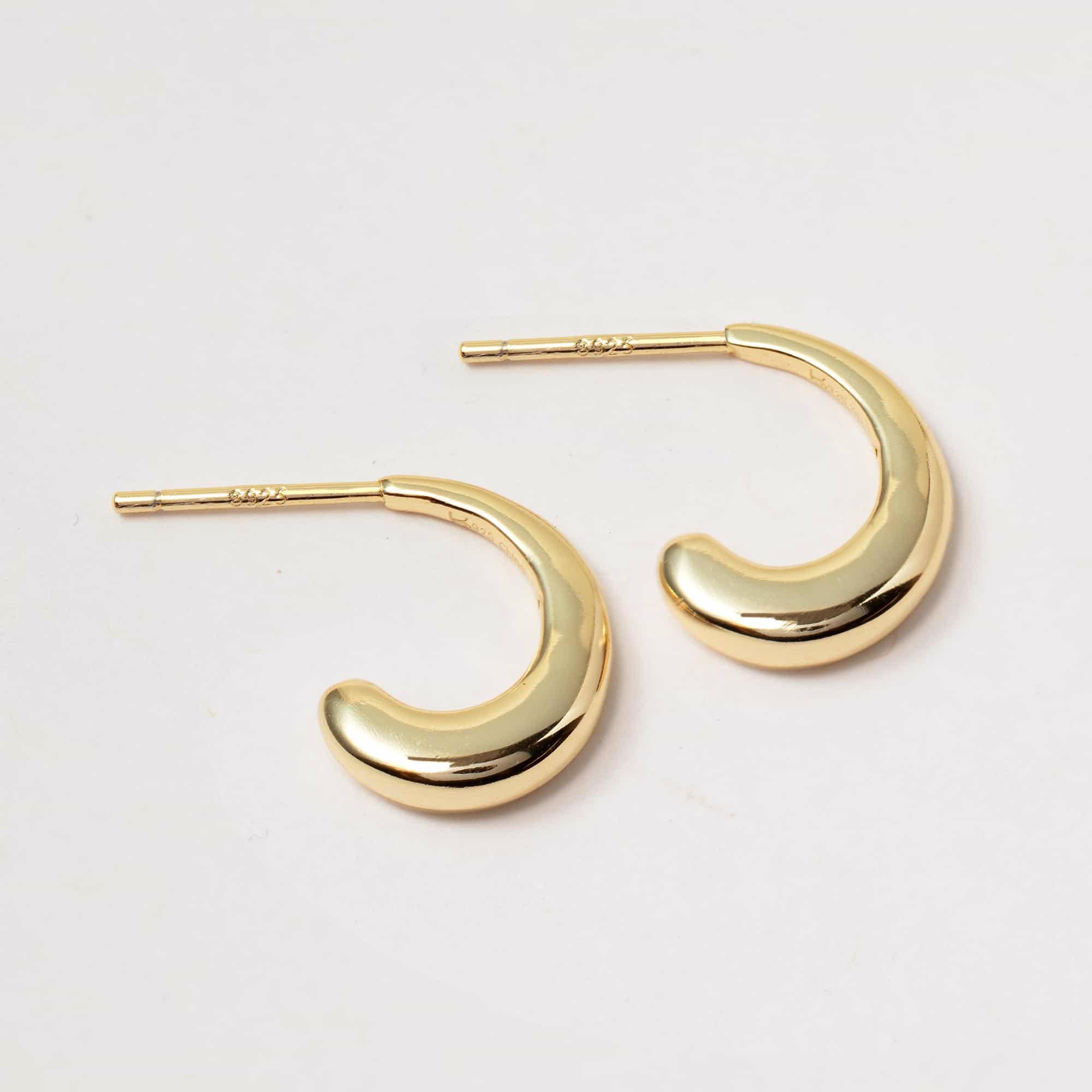 Gold vermeil small J hoop earrings shown at an angle with stamped post backs, on a white background