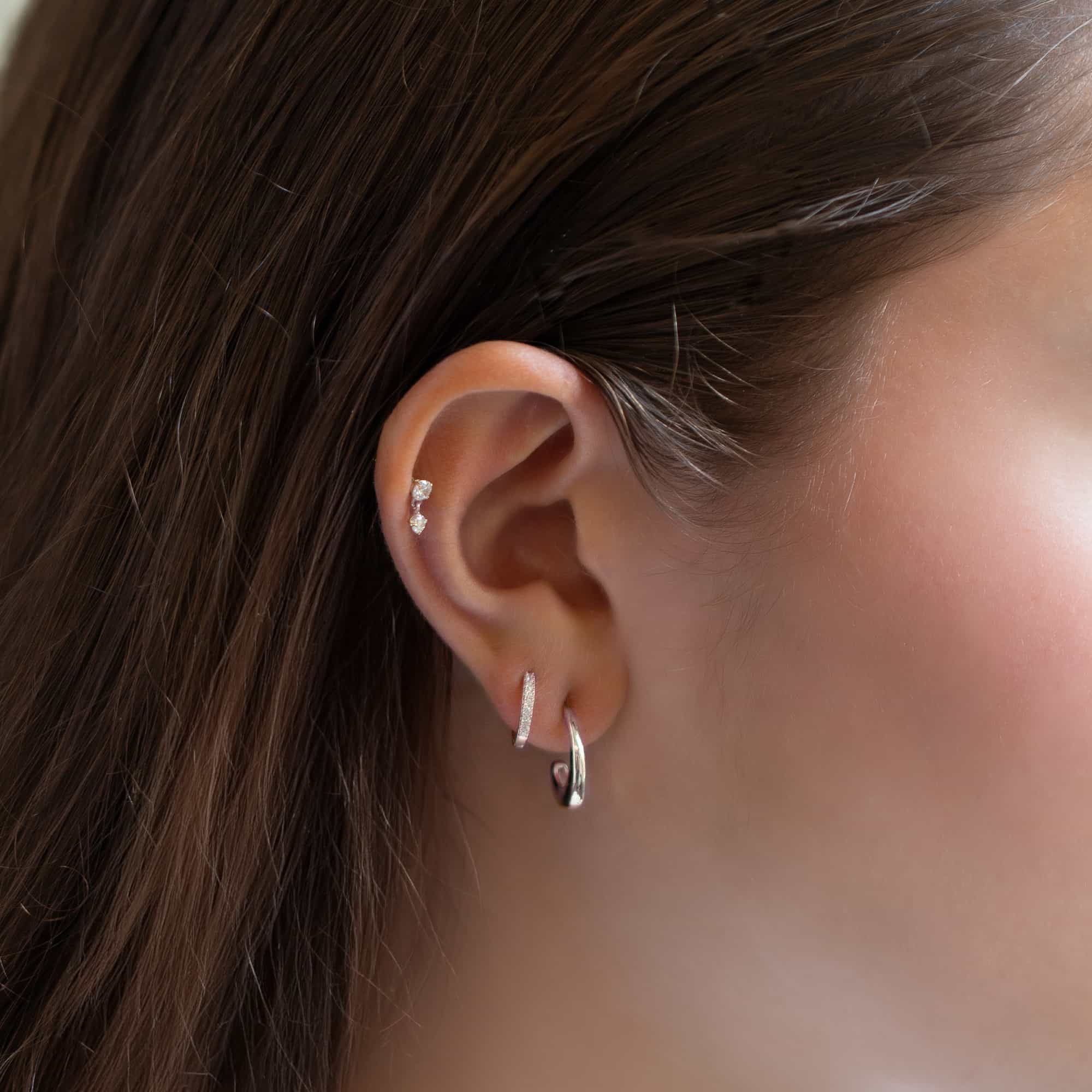 Sterling silver small J hoop styled with a glittery huggie and double-stone helix stud