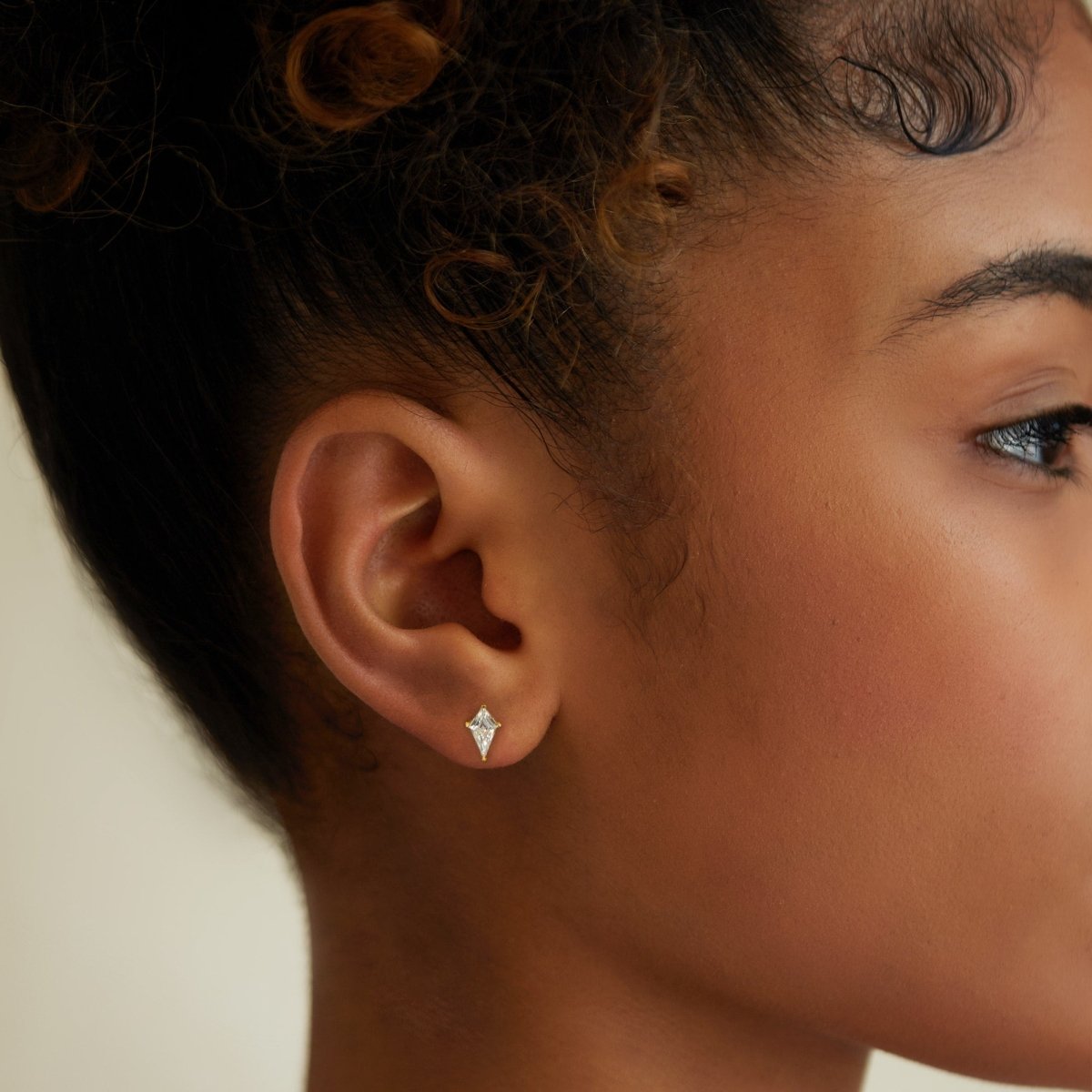 Gold vermeil kite-shaped clear crystal stud shown close-up on a model's earlobe