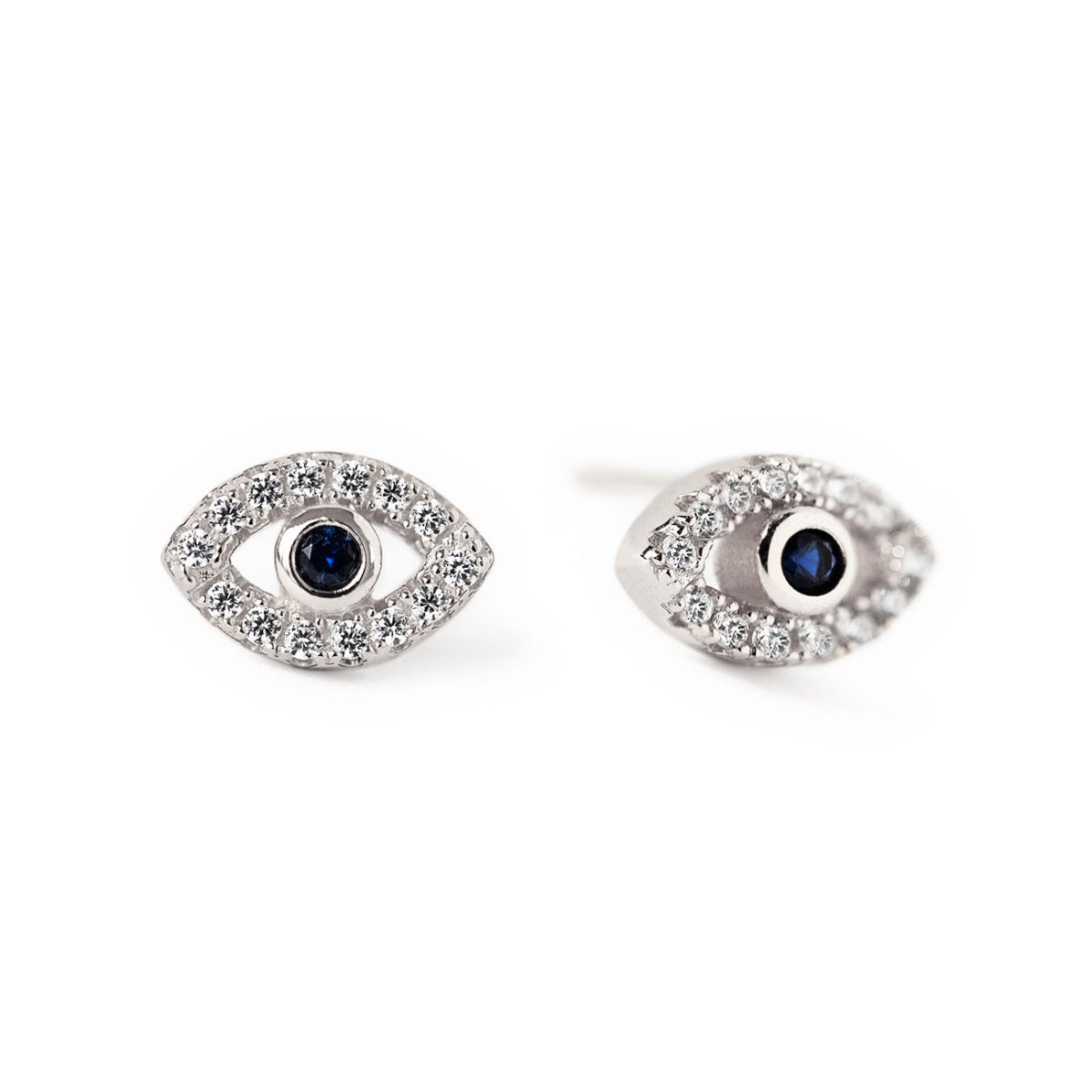 Pair of sterling silver evil eye studs with blue sapphire centers and clear stones, on a white background