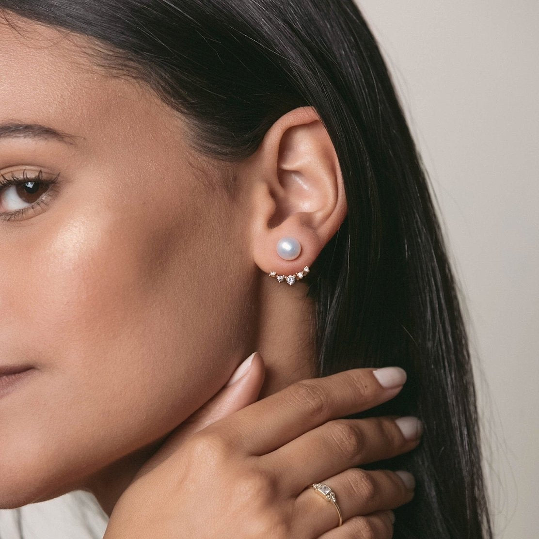 Gold vermeil pearl ear jacket studs with a crystal fan, shown on a model's lobe