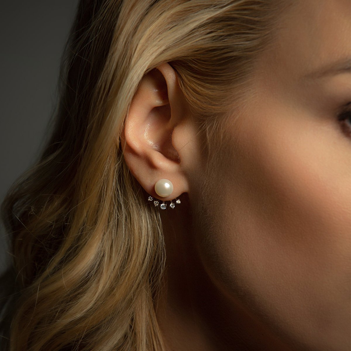 Sterling silver pearl ear jacket studs with a crystal fan, shown on a model's ear