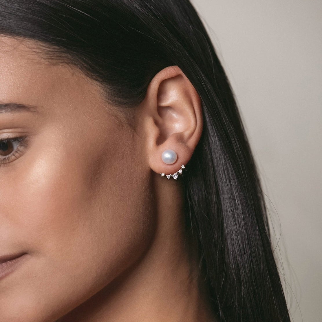 Sterling silver pearl ear jacket studs with a crystal fan, shown on a model's lobe