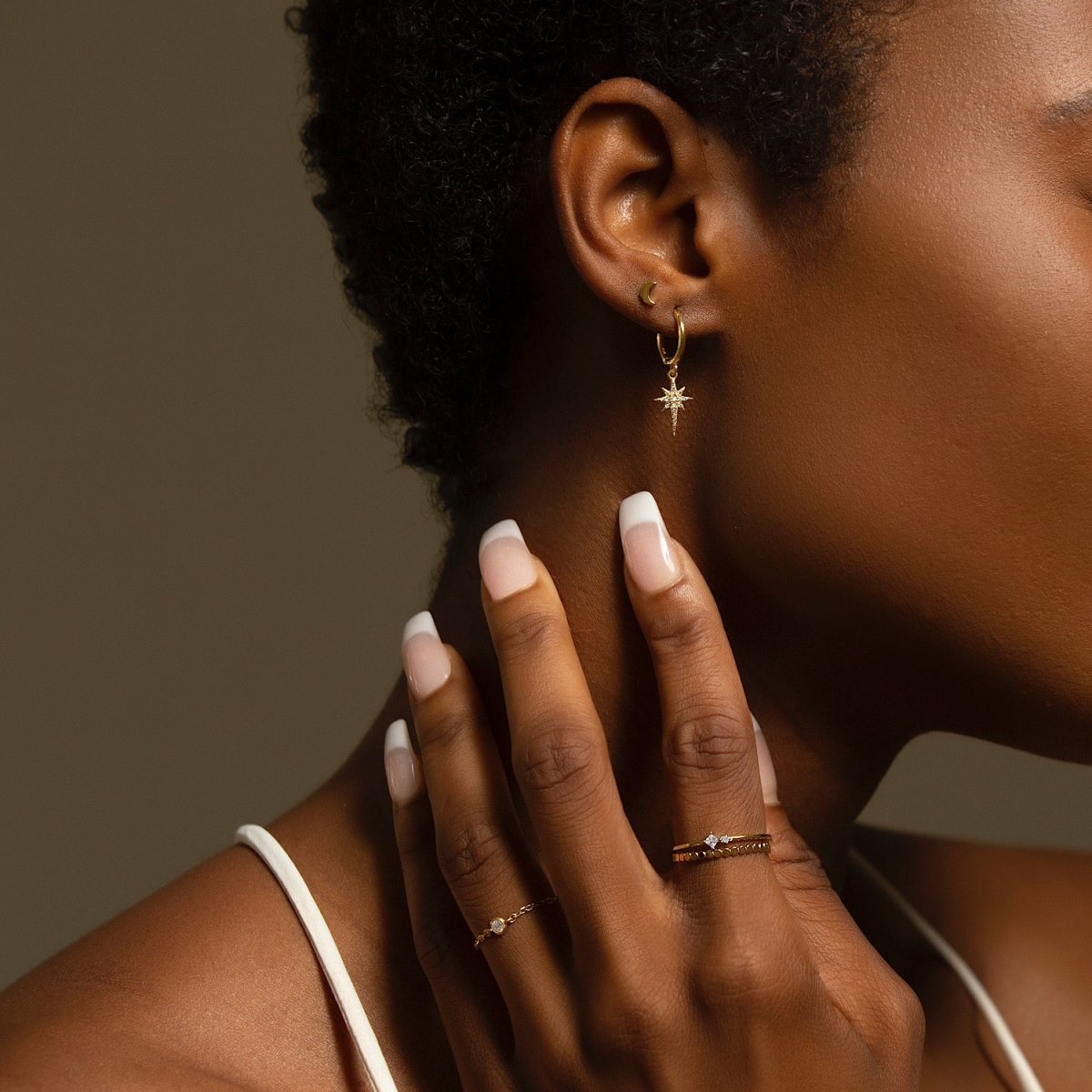 14K gold vermeil chain ring with a clear stone, stacked on a model's hand at her neck