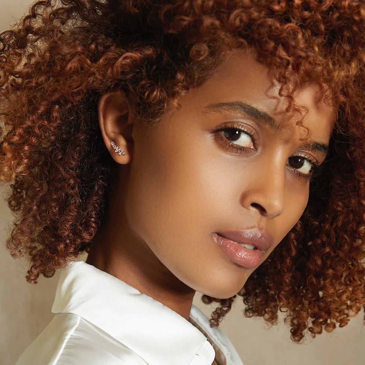 Gold vermeil marquise ear climber with white zirconia, shown on a model's ear, side angle