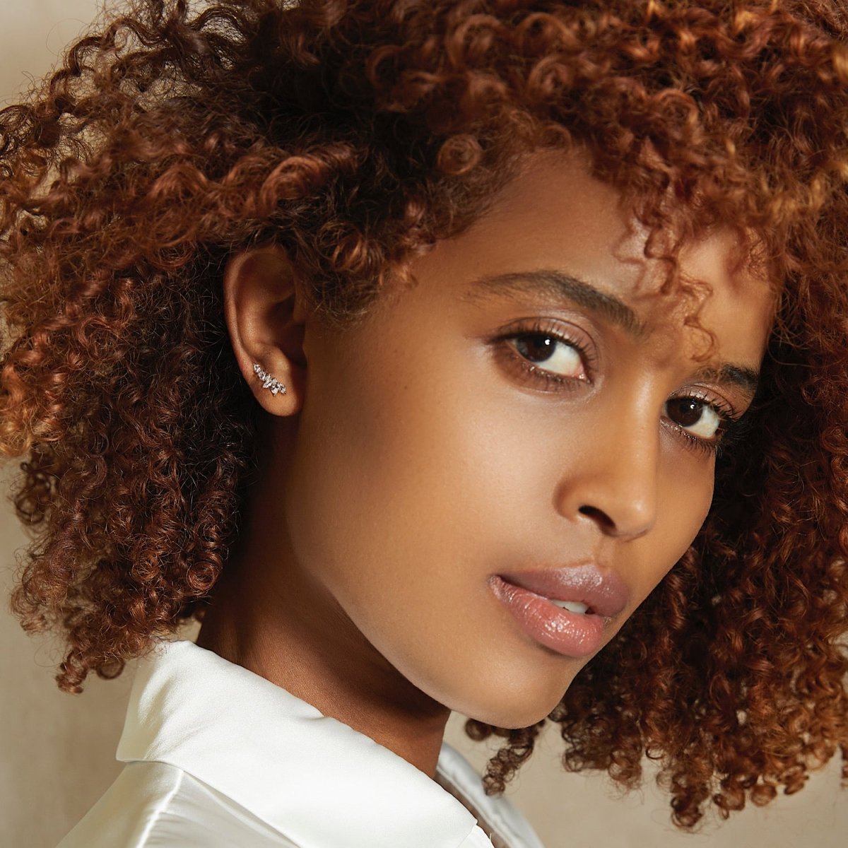 Sterling silver marquise ear climber with white zirconia, shown on a model's ear, close crop