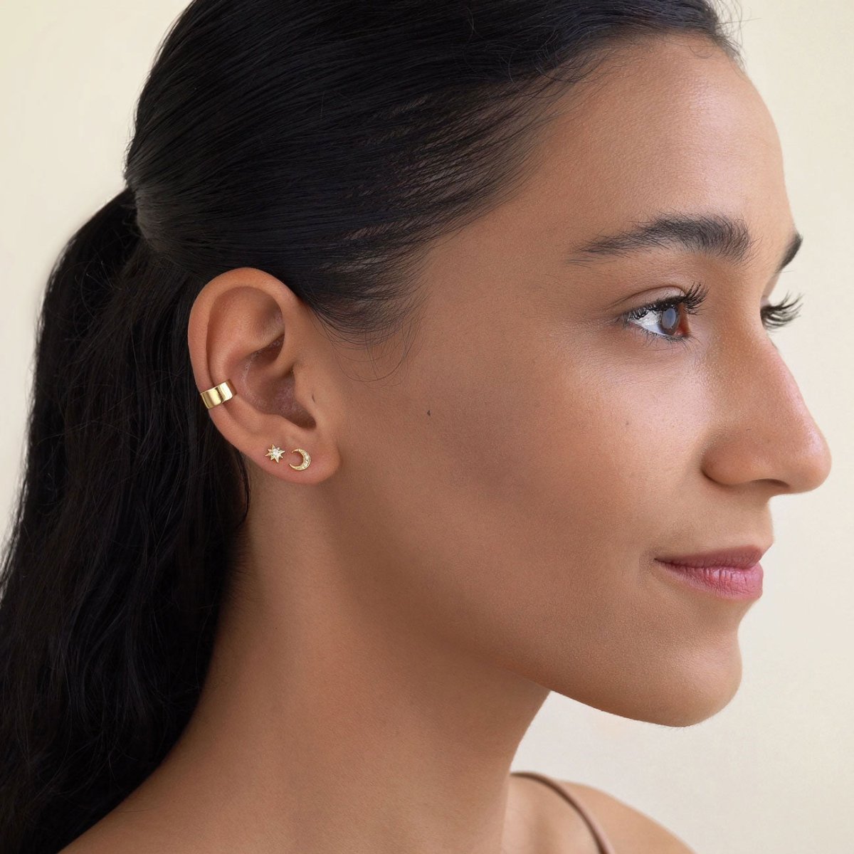 Gold vermeil star and crescent moon studs with an ear cuff, shown on a model's ear