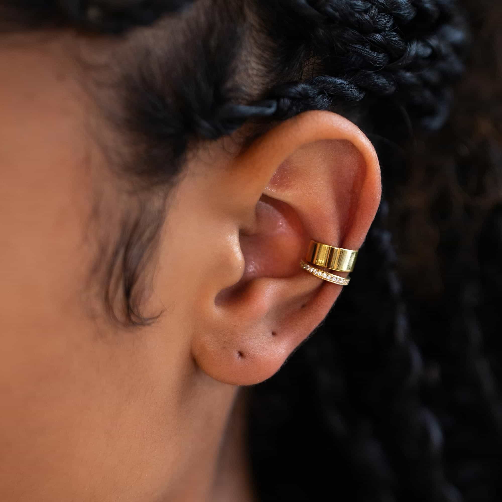 Gold vermeil plain and pave white zirconia ear cuffs stacked on a model's upper ear
