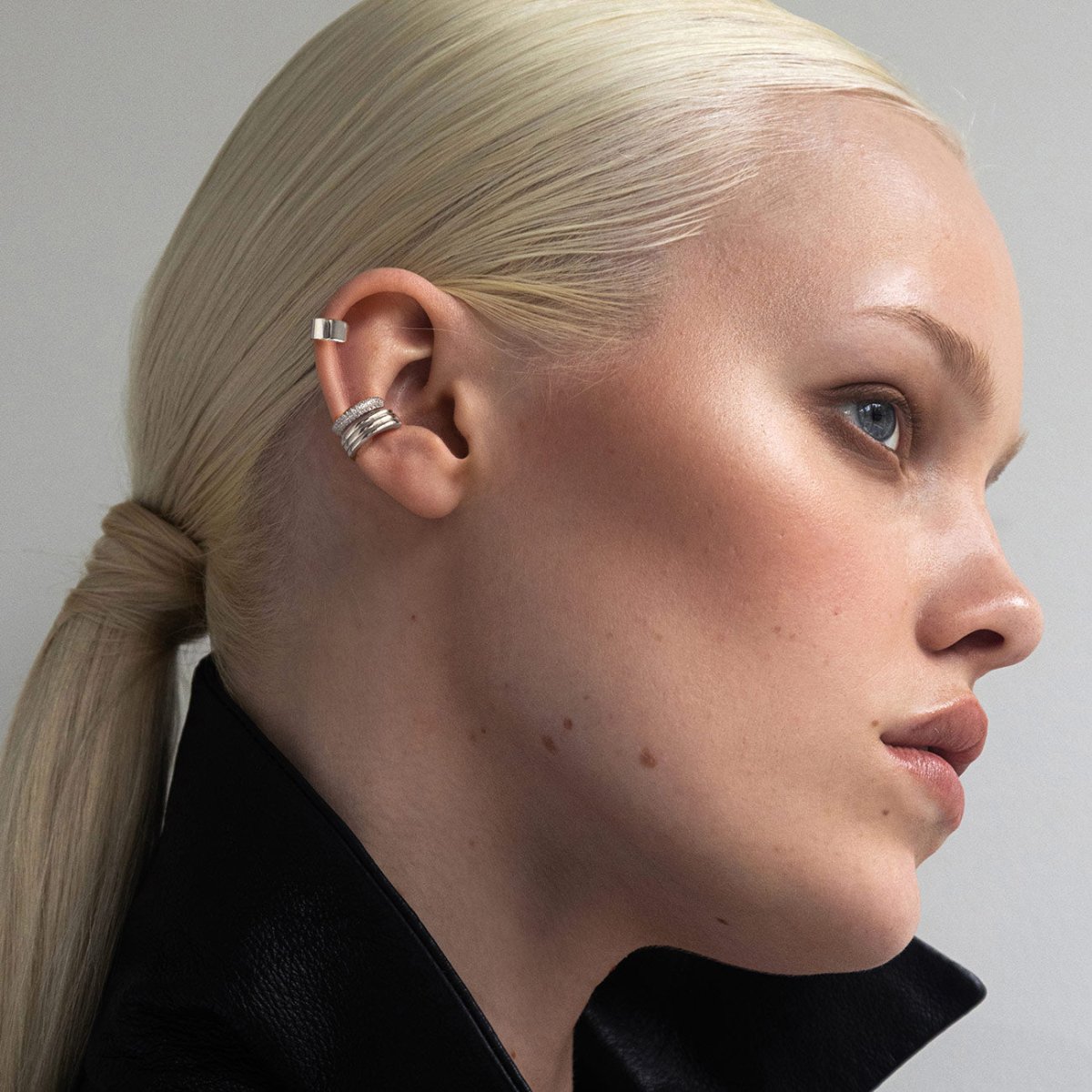 Sterling silver ear cuffs stacked on a model's ear, profile view
