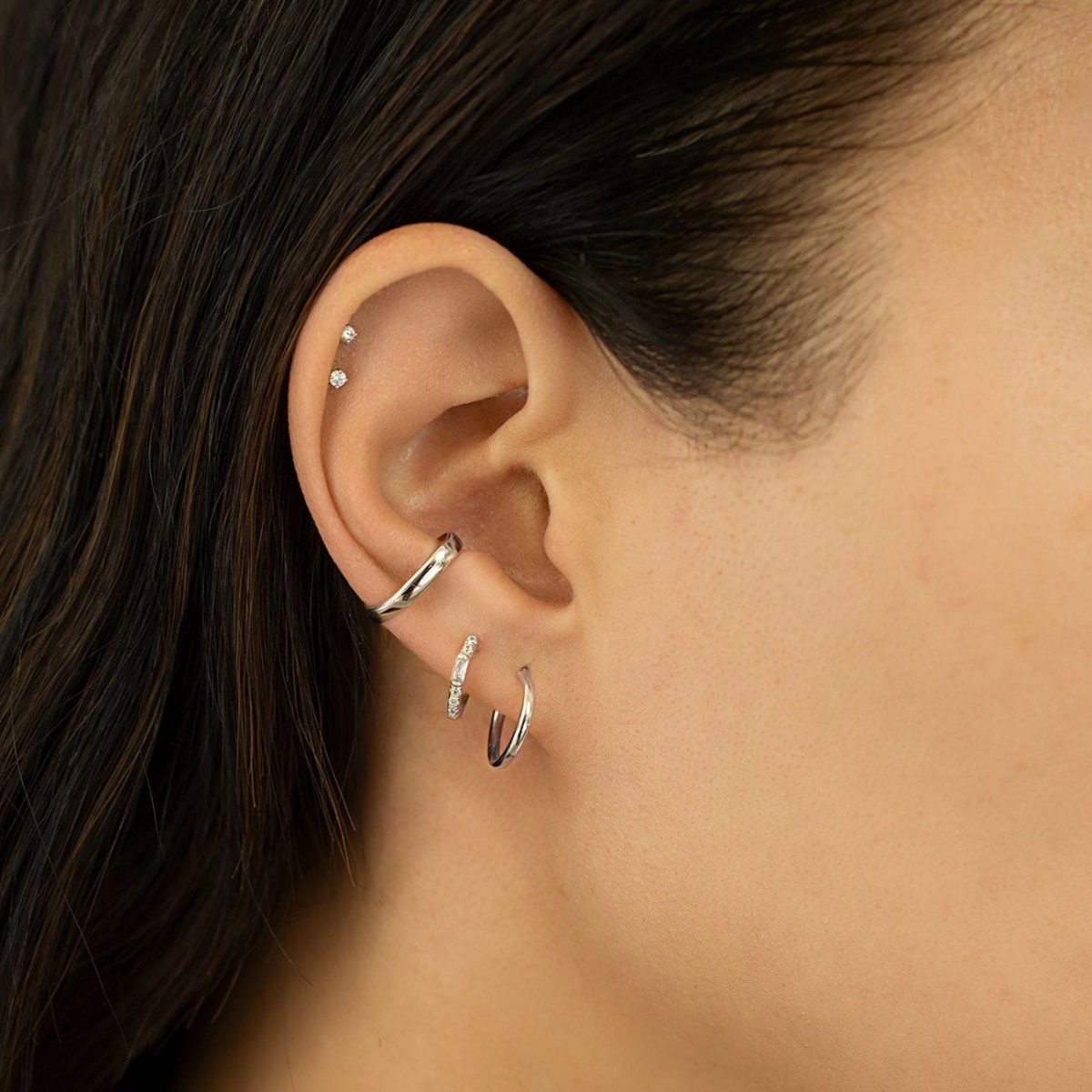 Sterling silver bold suspender ear cuff styled with hoops in an ear stack on a model