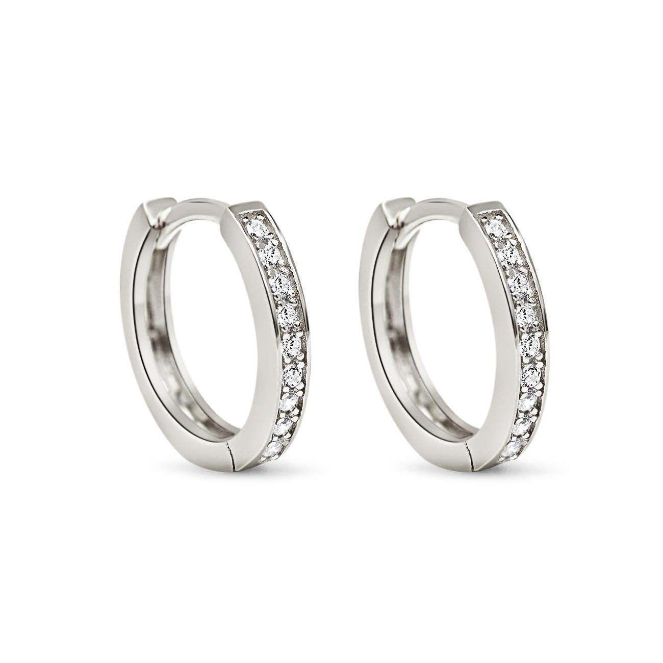 Pair of sterling silver pave huggie hoops set with clear white zirconia, on a white background