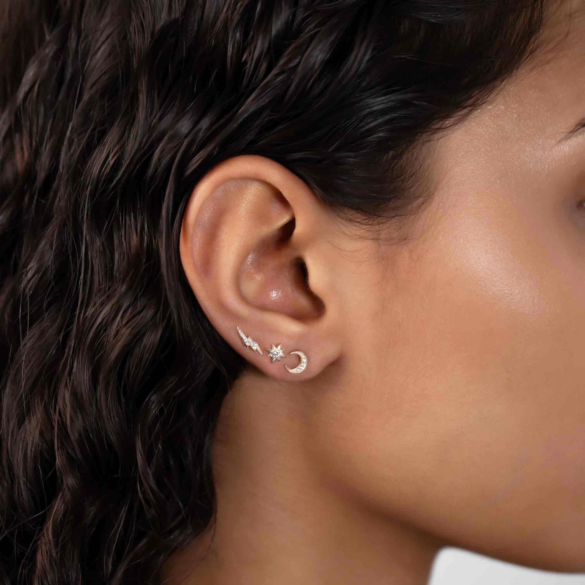 Sterling silver paved lightning bolt stud shown in an ear stack with star and moon studs
