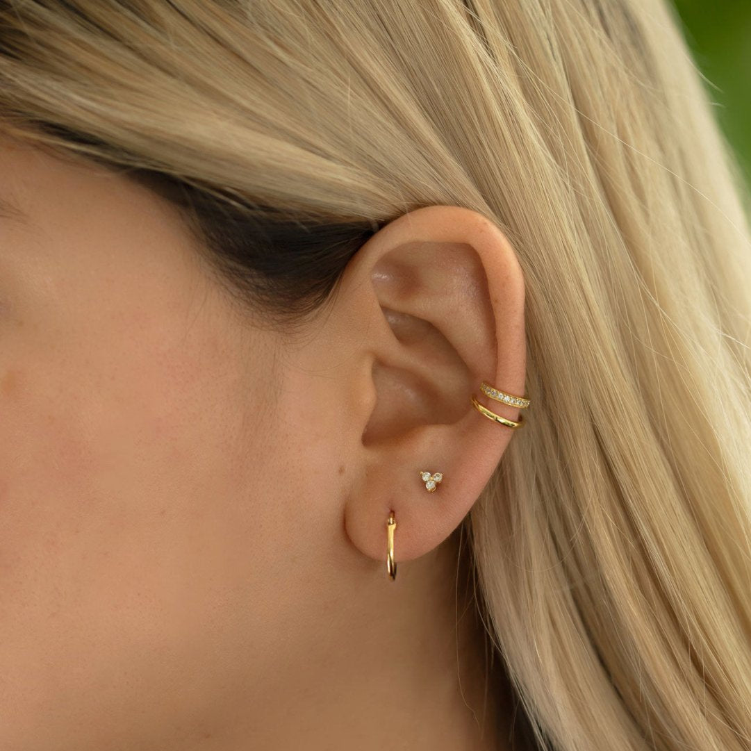 Gold vermeil pavé ear cuff with white zirconia, shown on a model's ear with a hoop