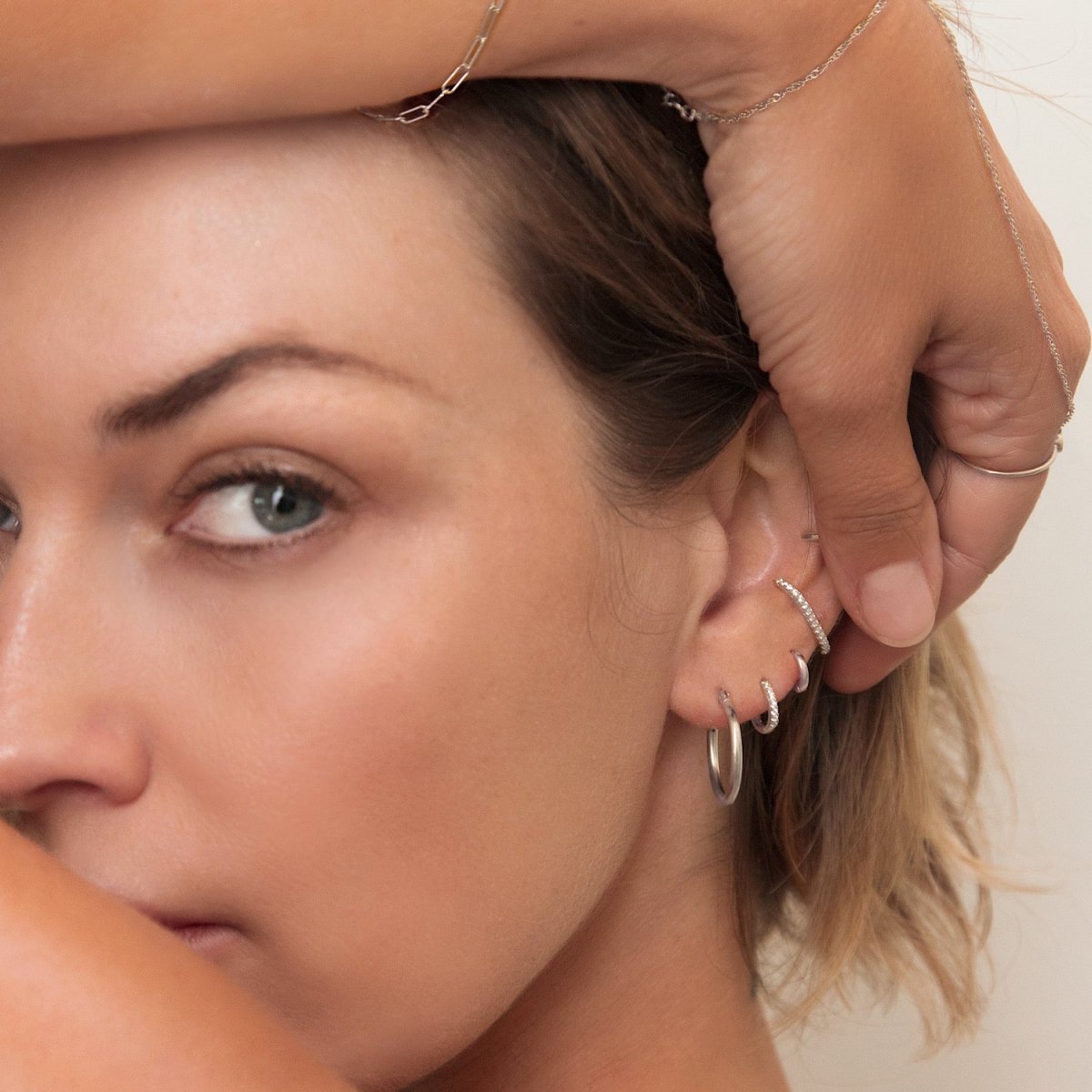 Sterling silver thin hoop shown on a model's ear in a lobe and helix stack