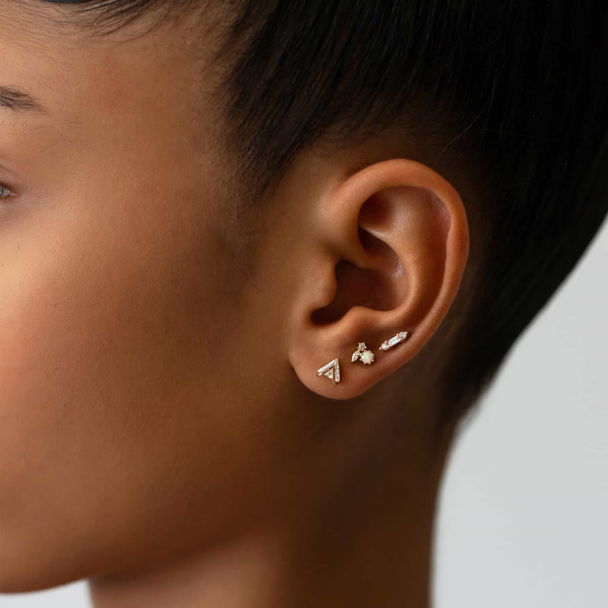 Rose gold vermeil baguette bar studs with clear stones, shown on a model's lobe in an ear stack