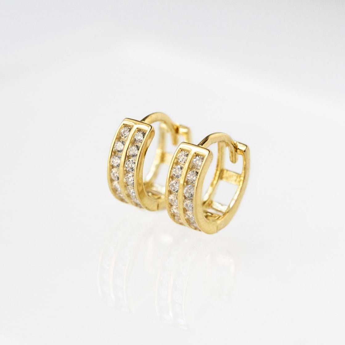14K gold double row pavé huggie hoops with clear stones, shown in two sizes on a white background